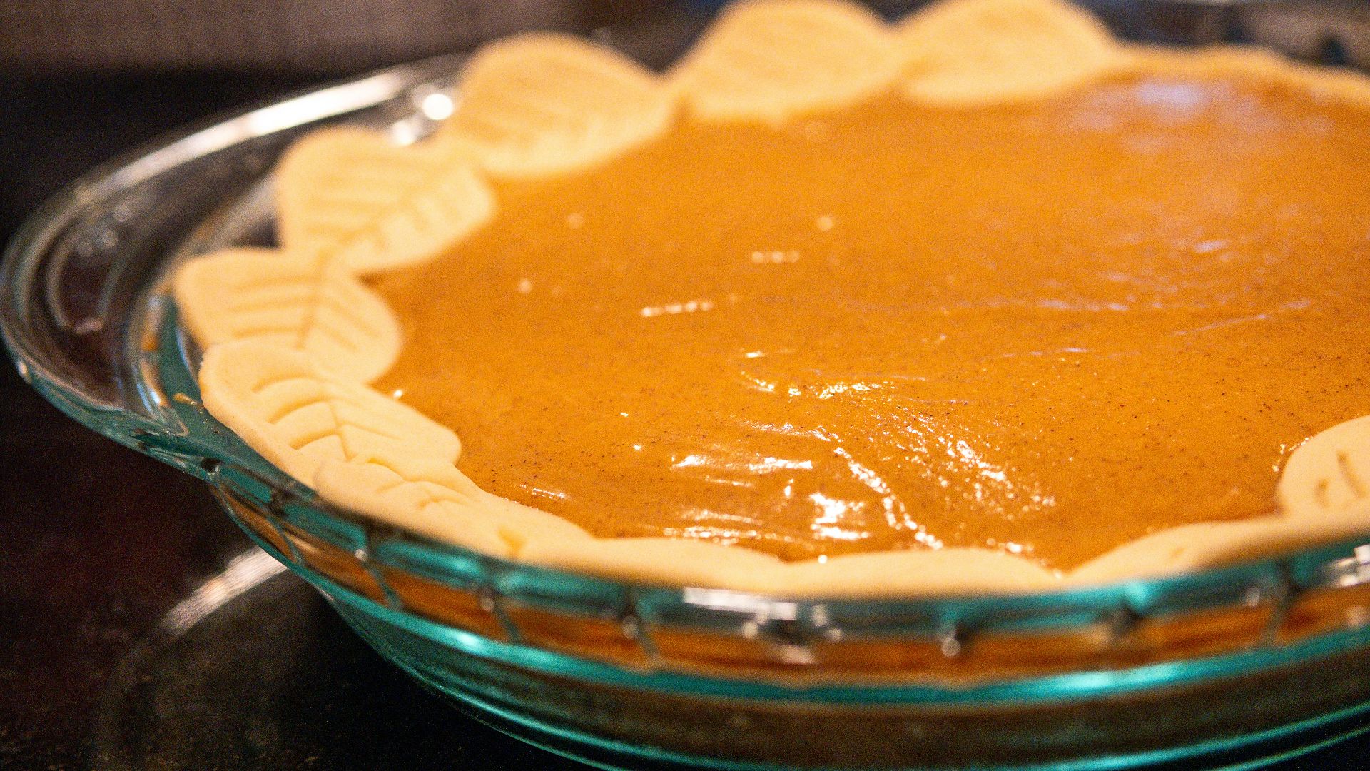 A pumpkin pie in a glass dish