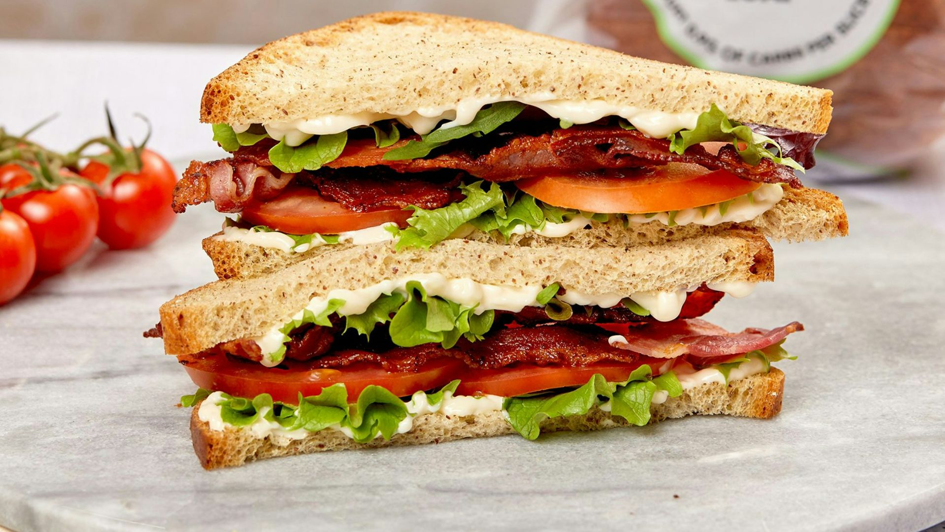 burger with tomato and lettuce on white ceramic plate