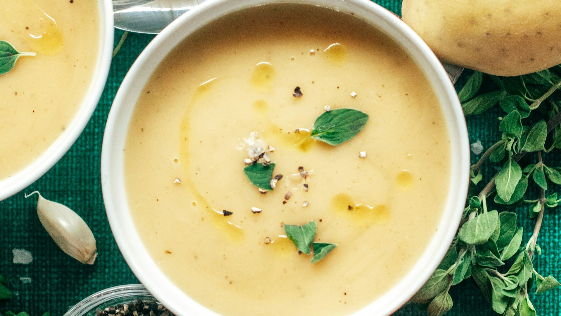three bowls of soup on a green cloth