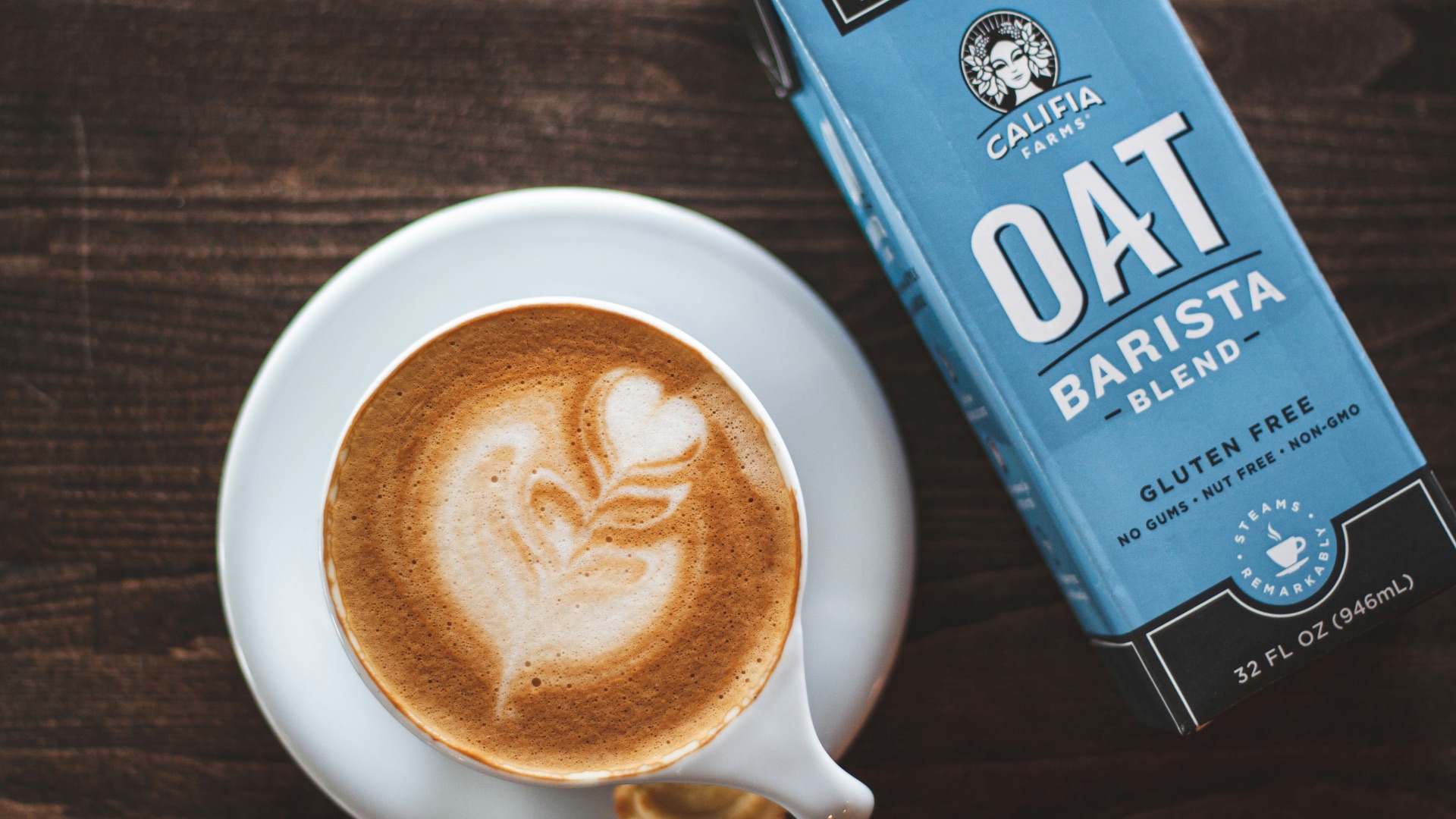 cup of latte beside oat barista box