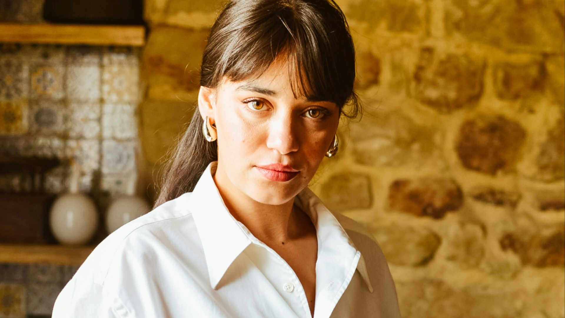 A woman in a white shirt and black skirt
