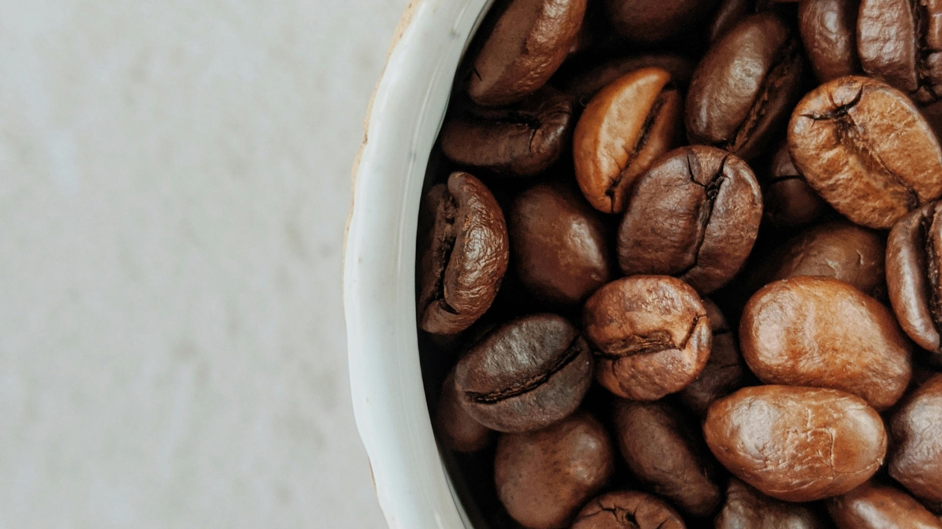 brown coffee beans on white ceramic bowl