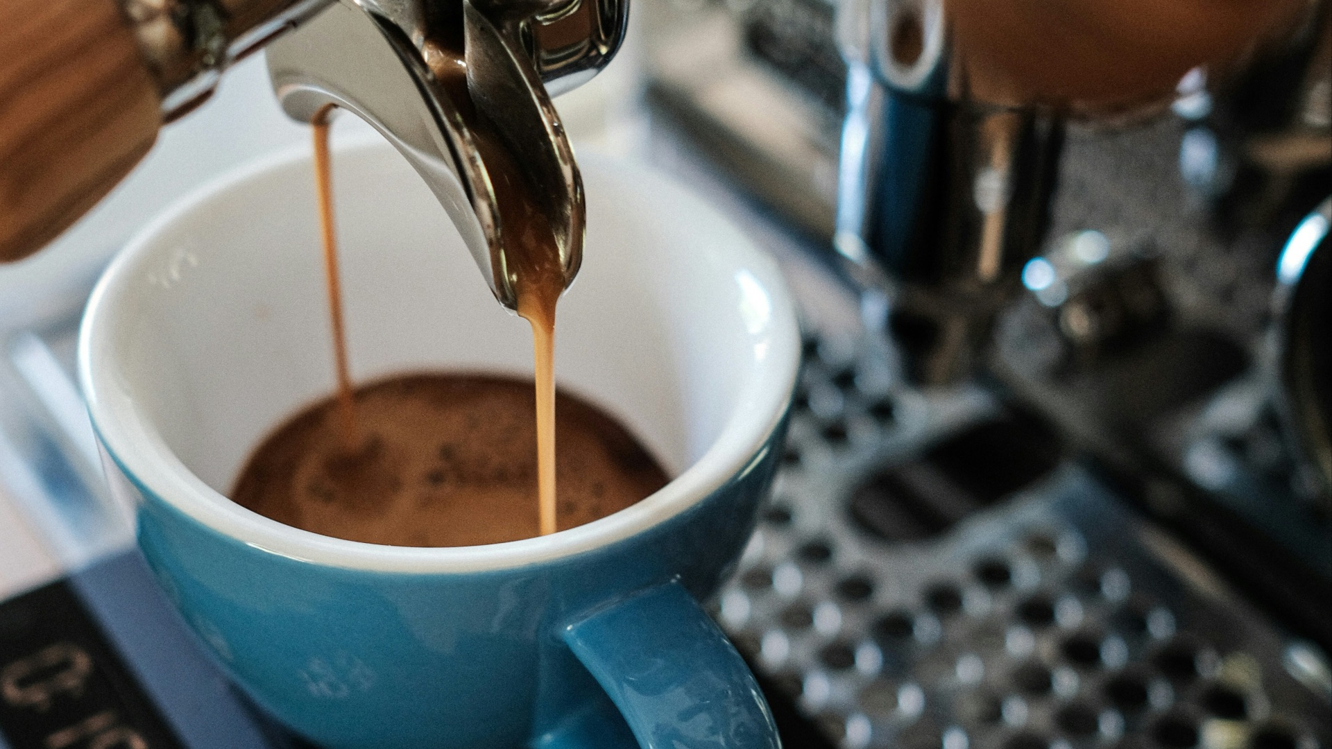 blue ceramic mug on silver espresso machine