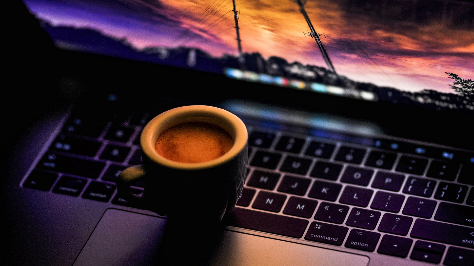 black ceramic coffee mug on MacBook Pro