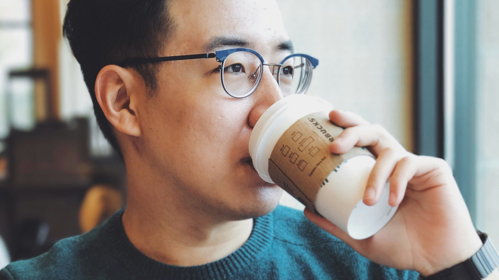 man holding Starbucks disposable cup