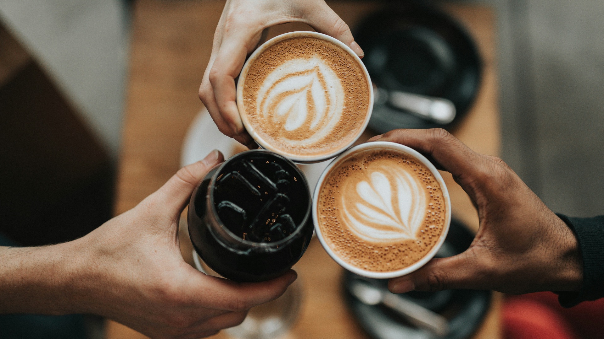 three person holding beverage cups