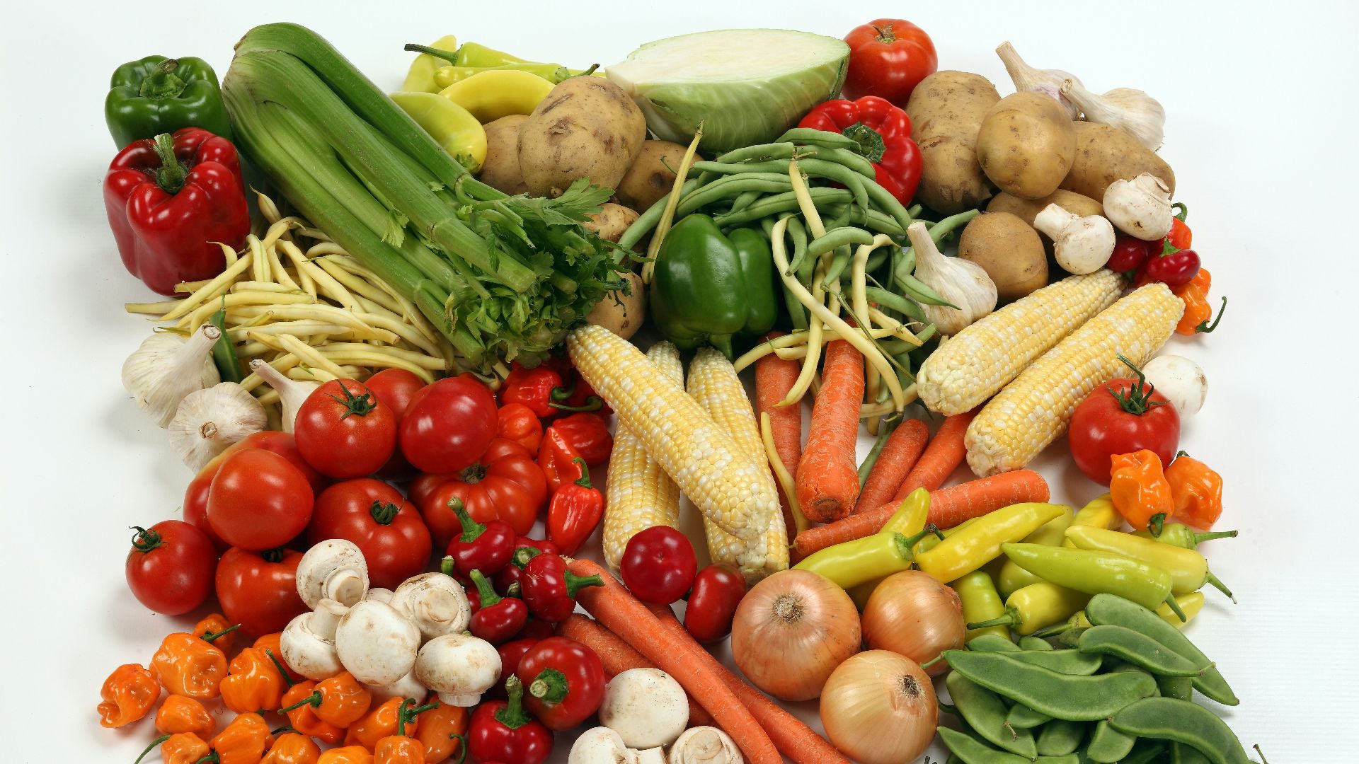 a pile of different types of vegetables on a white surface