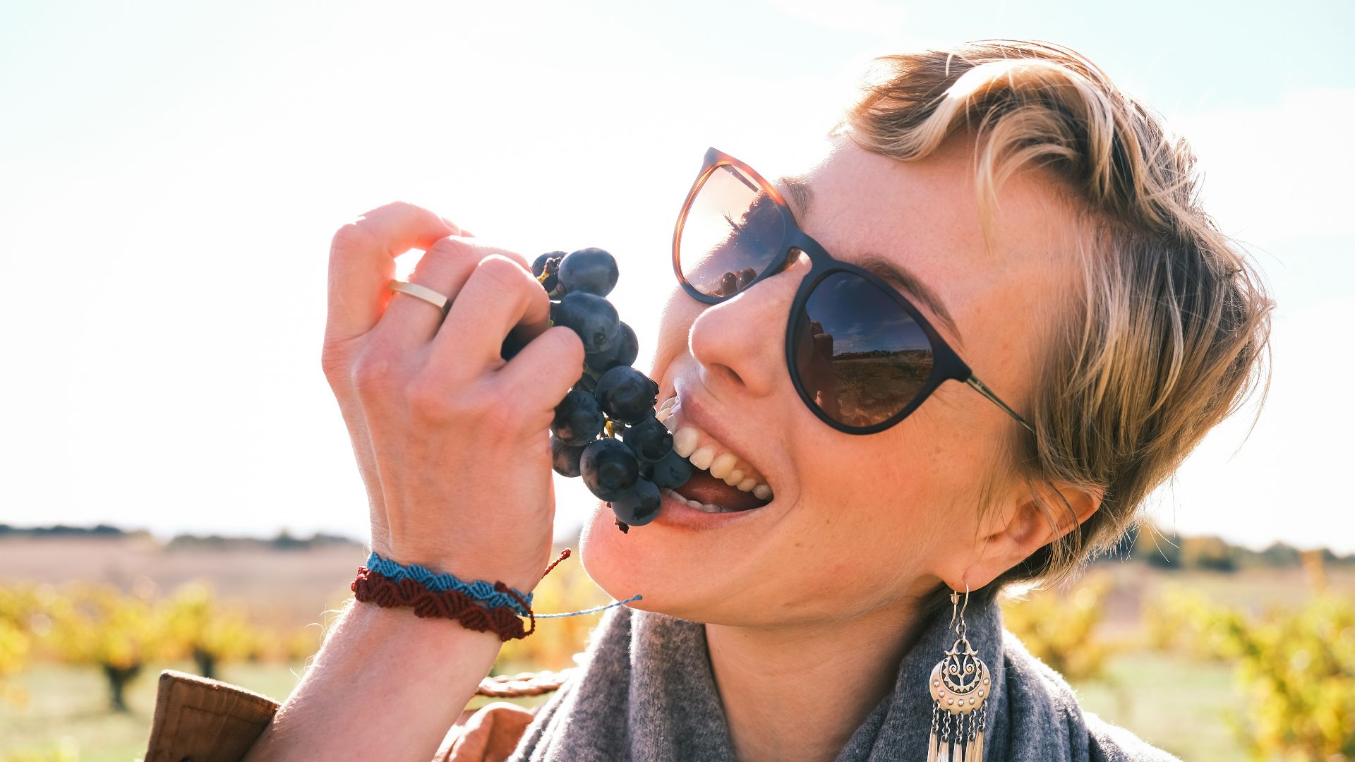 Woman eating grapes in a vineyard