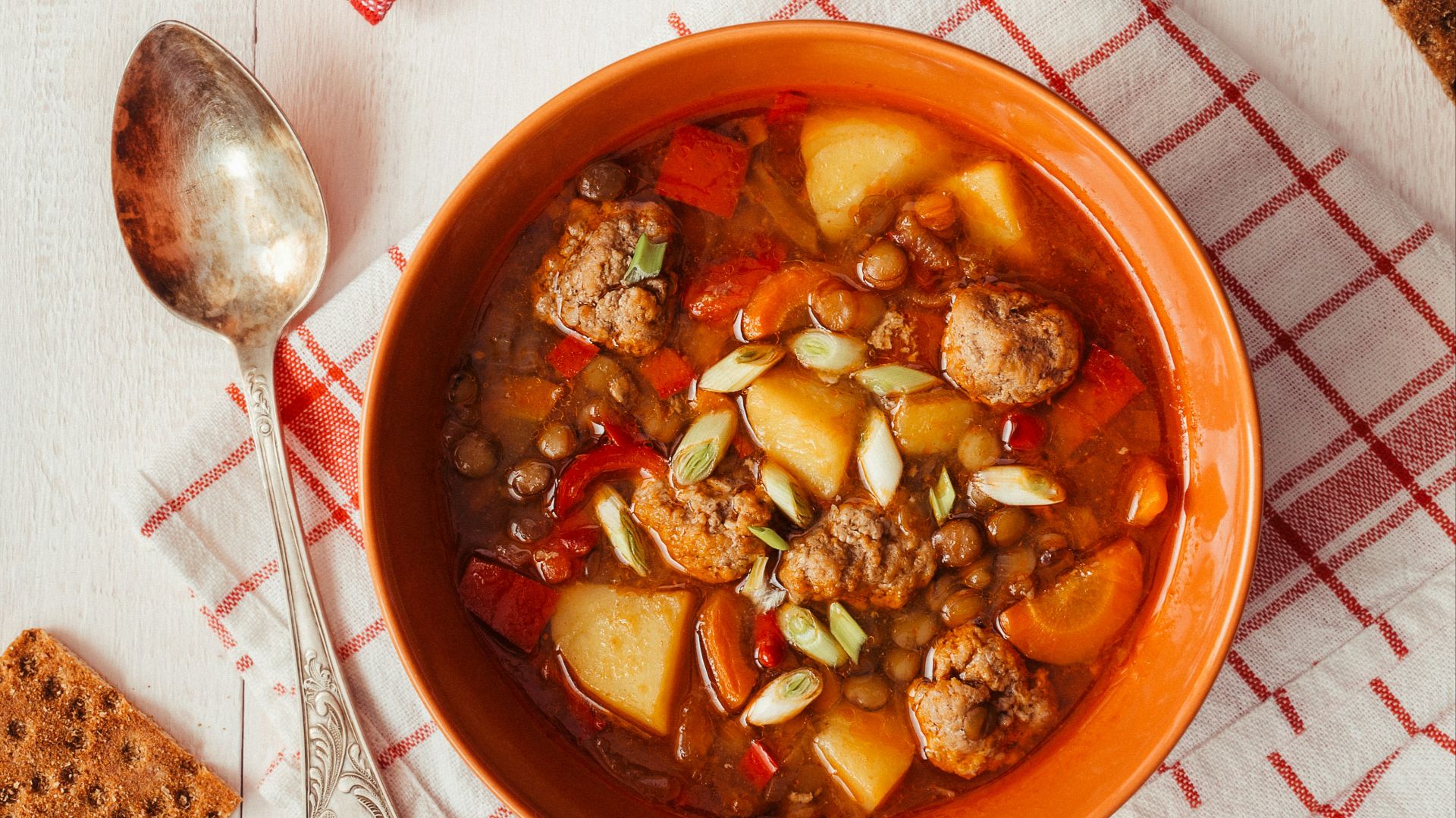 two bowls of soup on a table with crackers