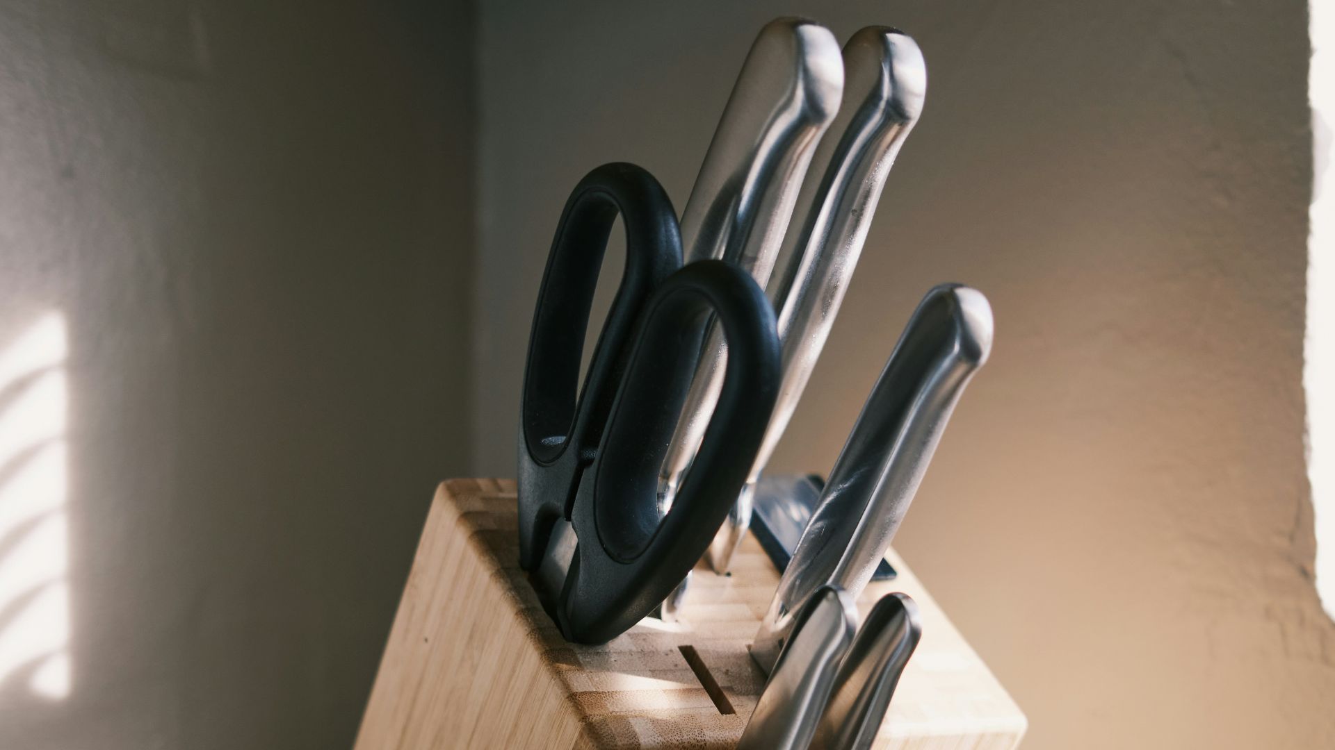 a wooden block with a knife holder holding knives