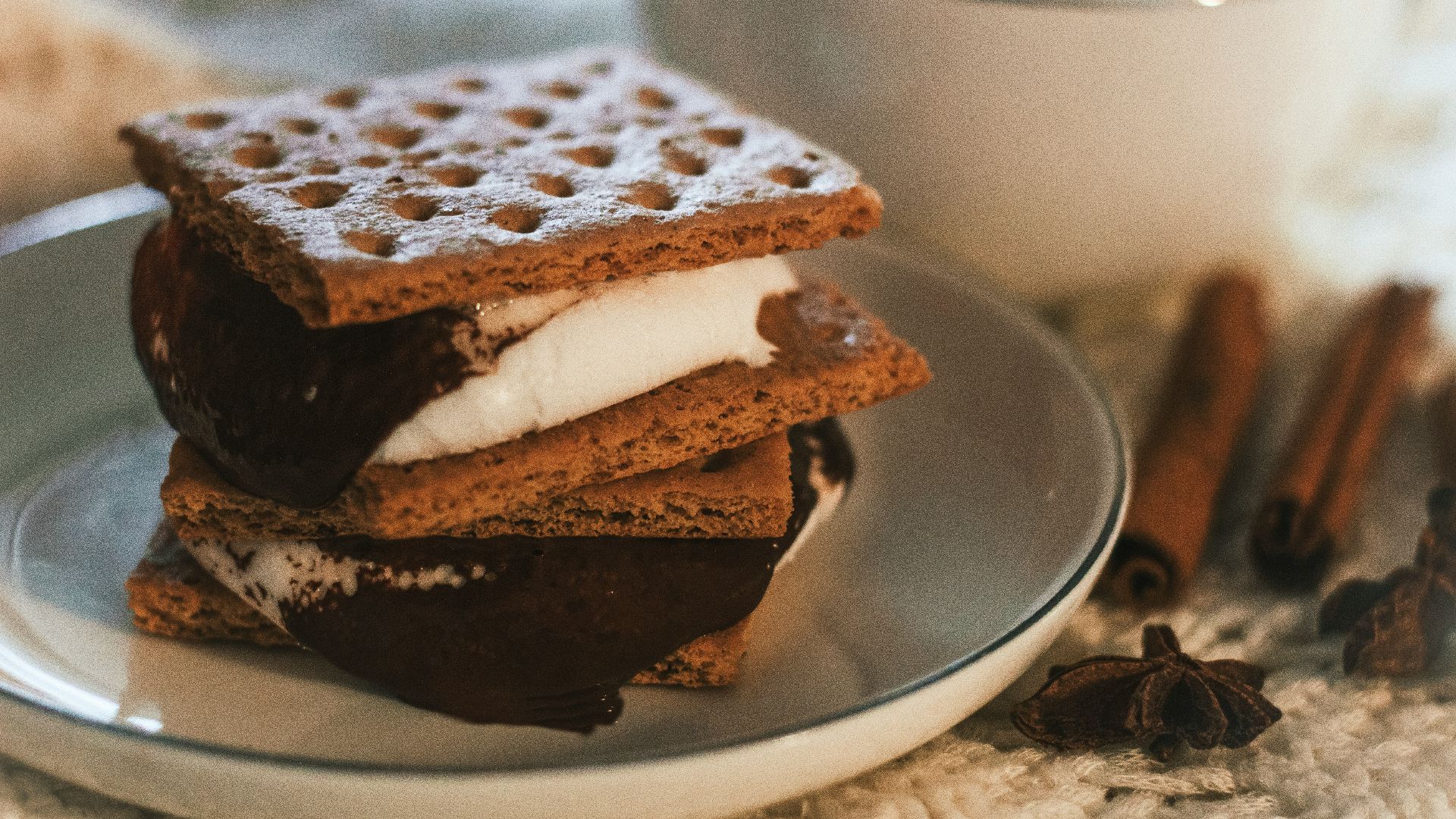 a stack of waffle sandwiches on a plate next to a cup of coffee