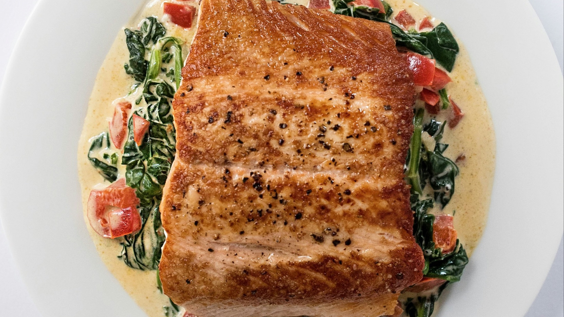 a white plate topped with a piece of fish