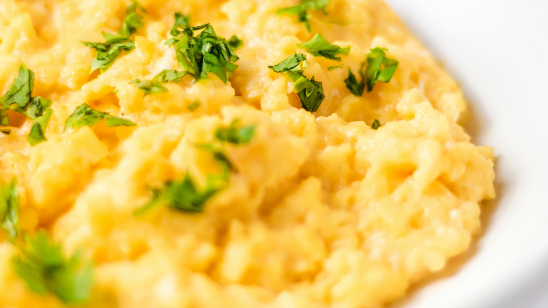 a bowl of mashed potatoes with parsley on top
