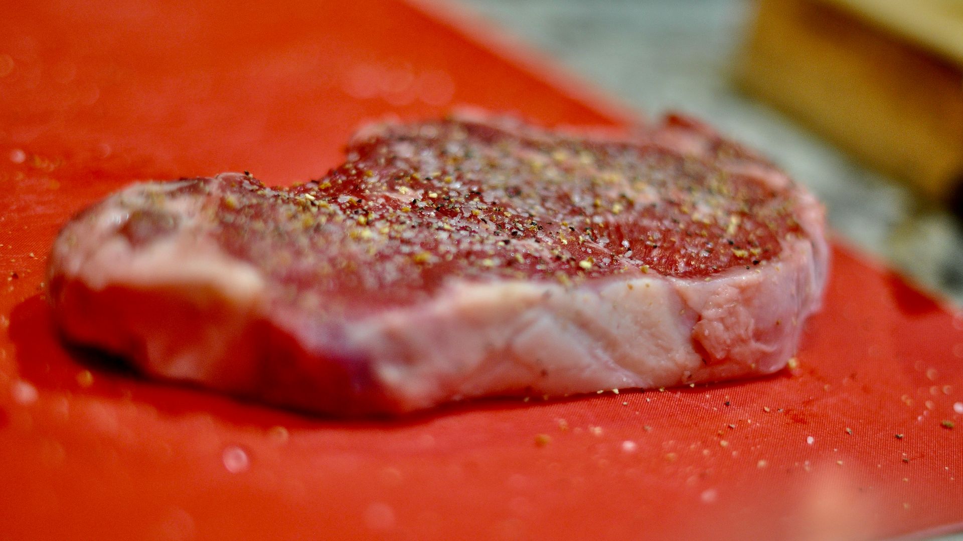 a piece of meat sitting on top of a red cutting board