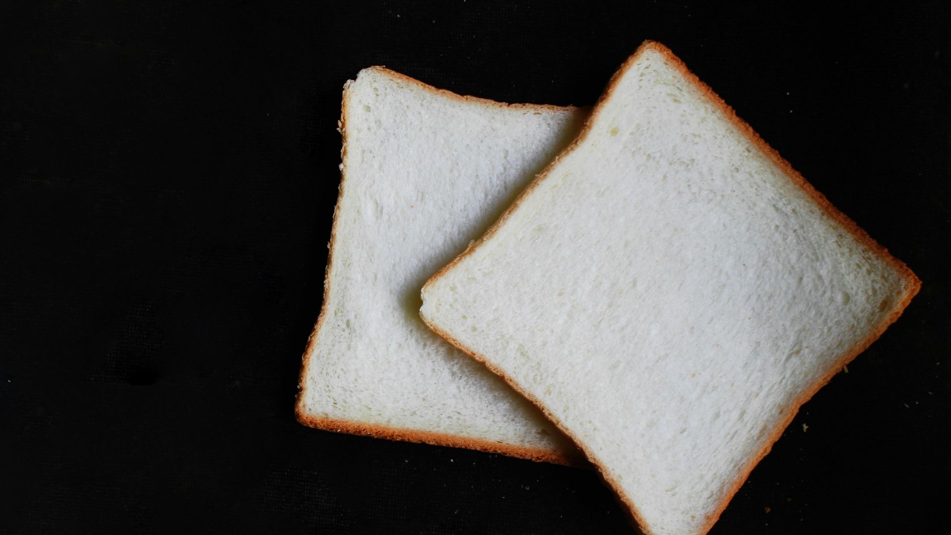 two slices of breads on top of black surface