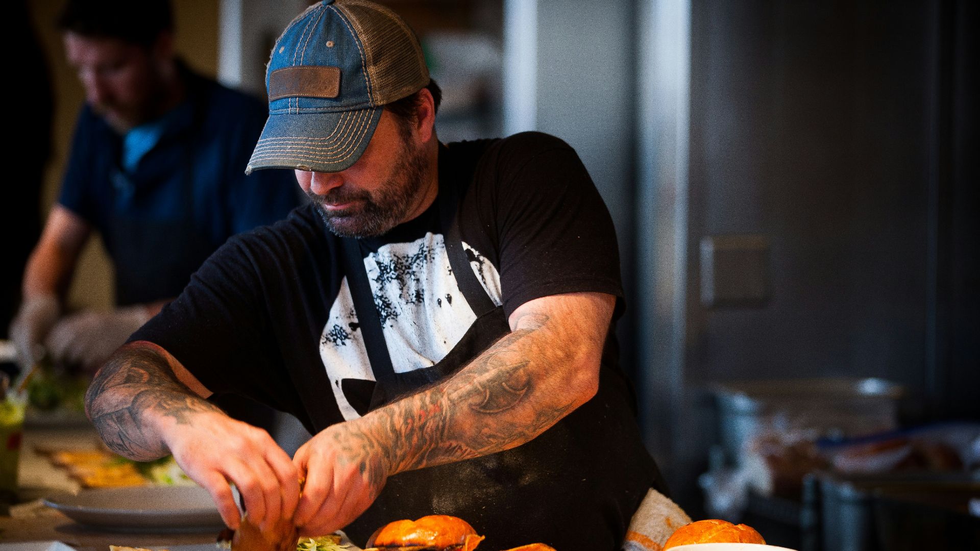 man standing beside table while holding food