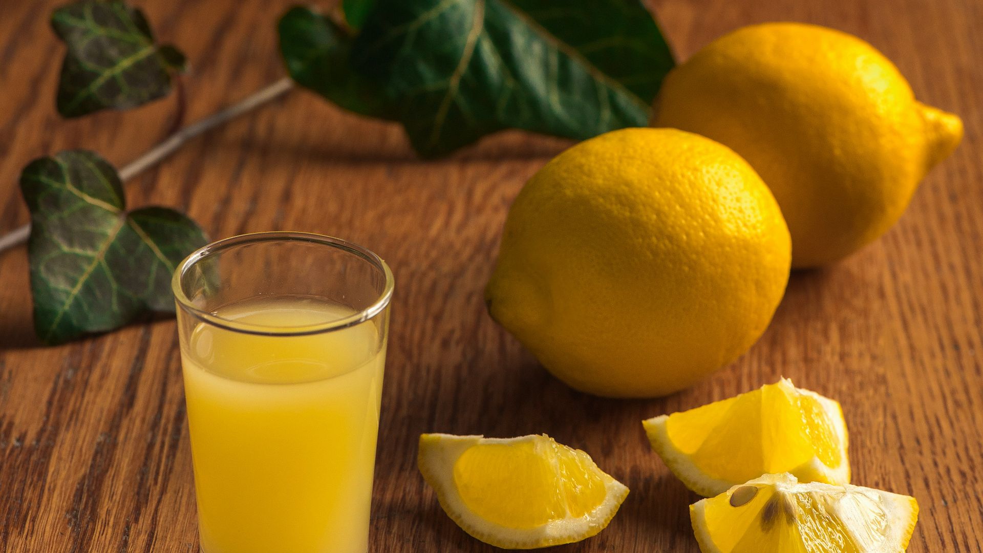 a glass of orange juice next to sliced lemons