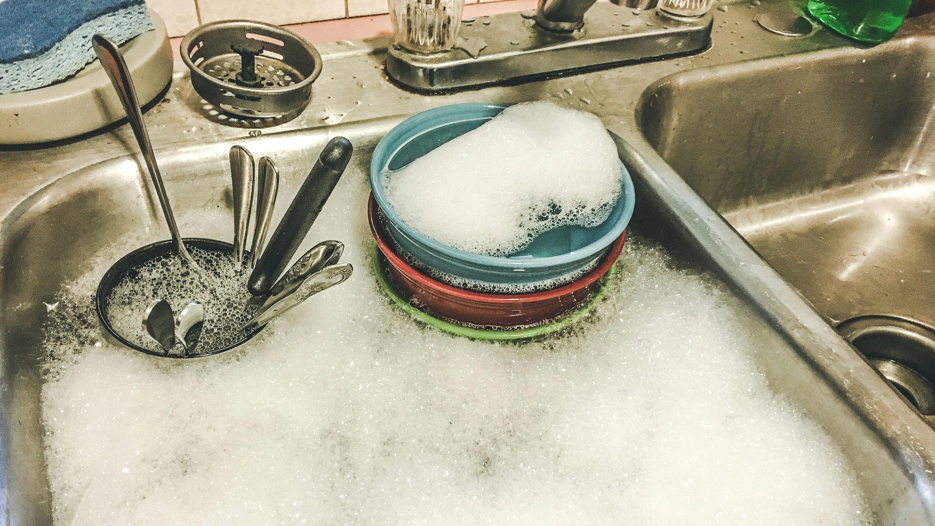stainless steel spoons on white ceramic sink