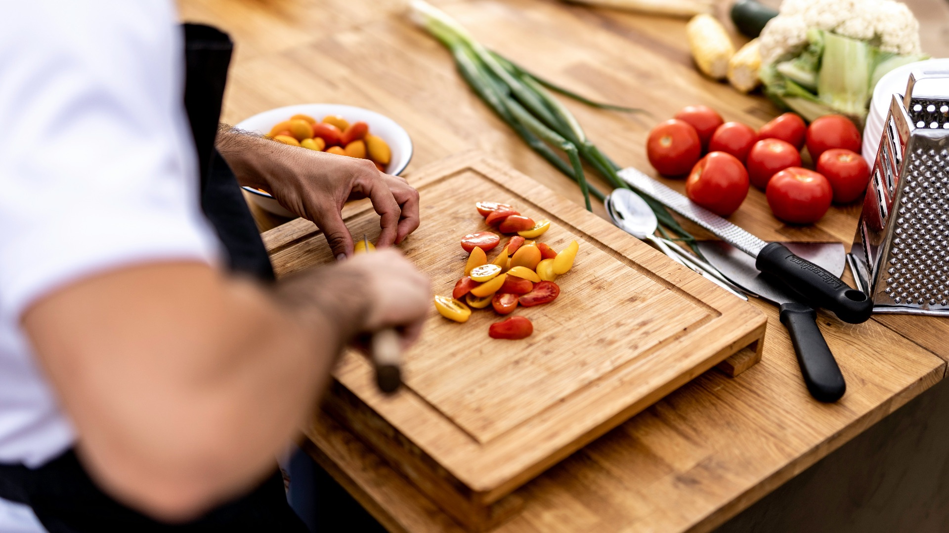 a person cutting up vegetables on a cutting board