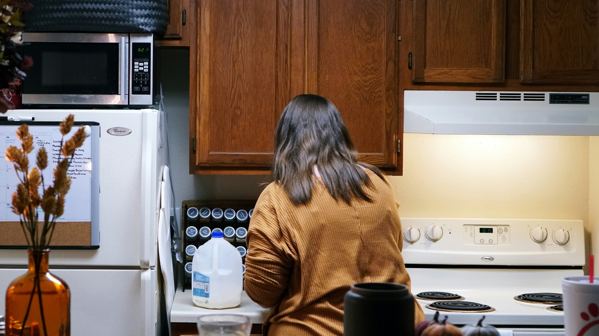 a woman standing in a kitchen next to a stove top oven