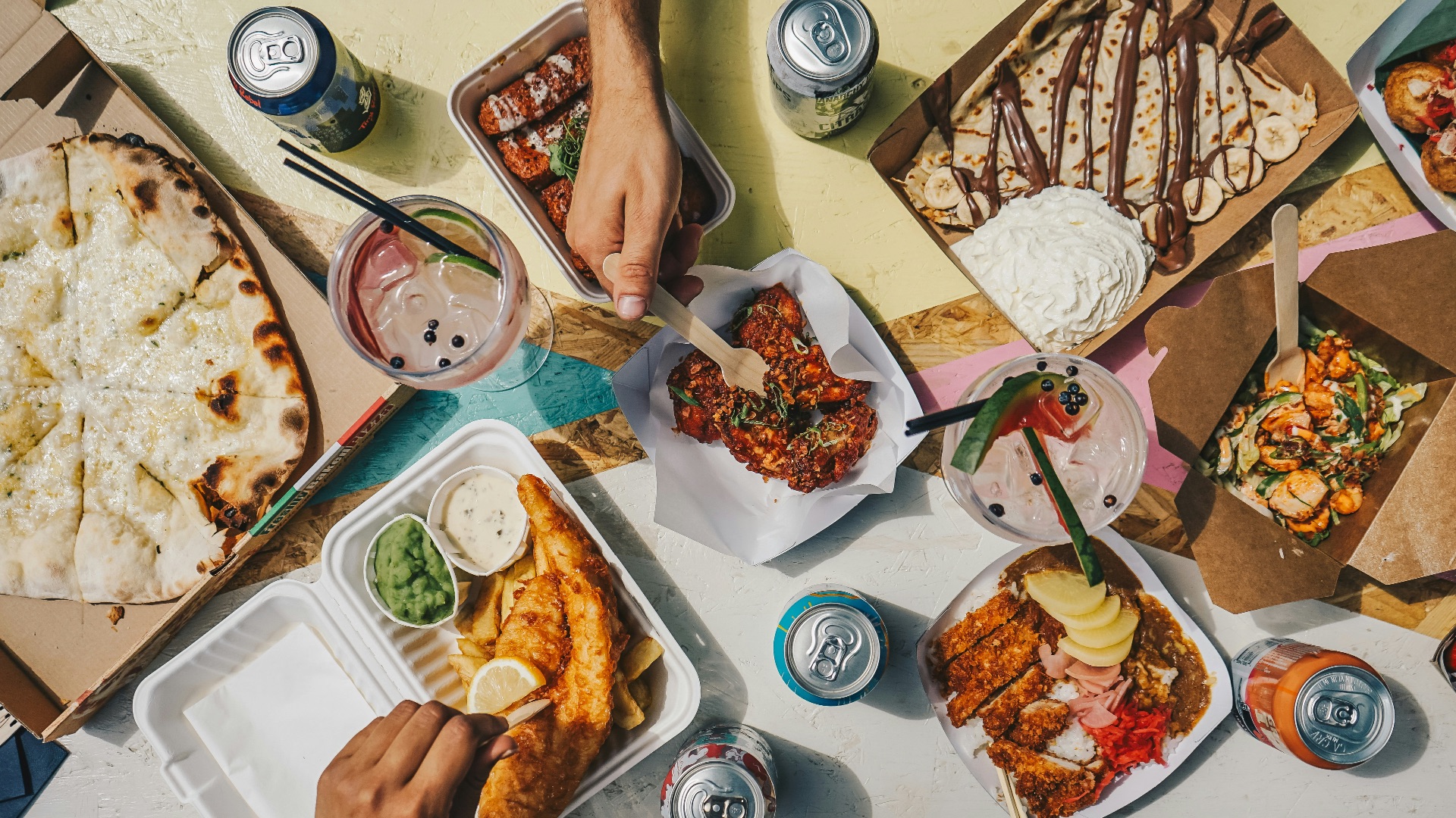 a group of people sitting around a table filled with food