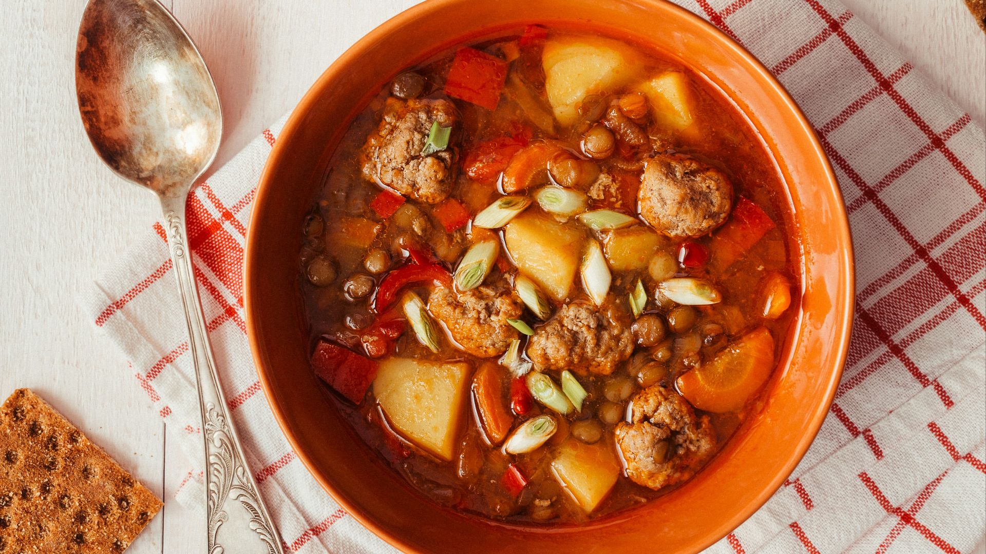 two bowls of soup on a table with crackers