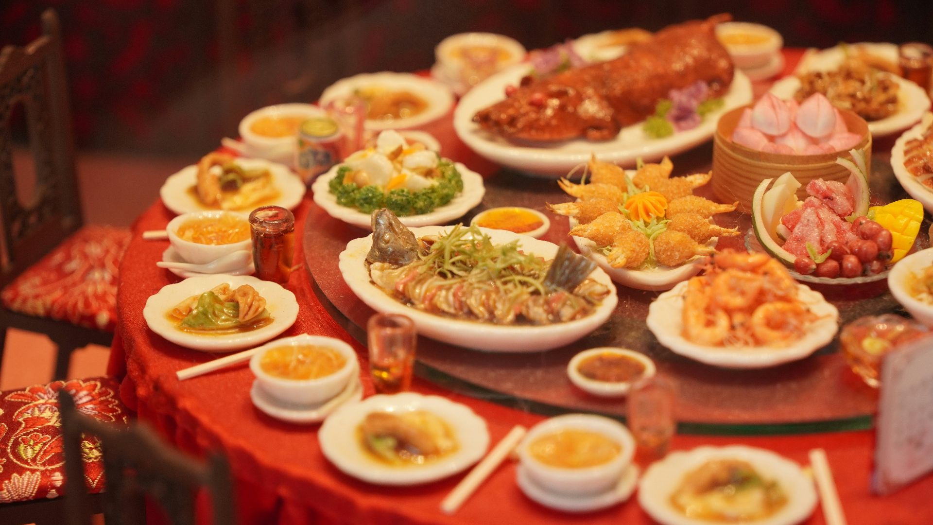 Table laden with diverse asian dishes and roasted pig.