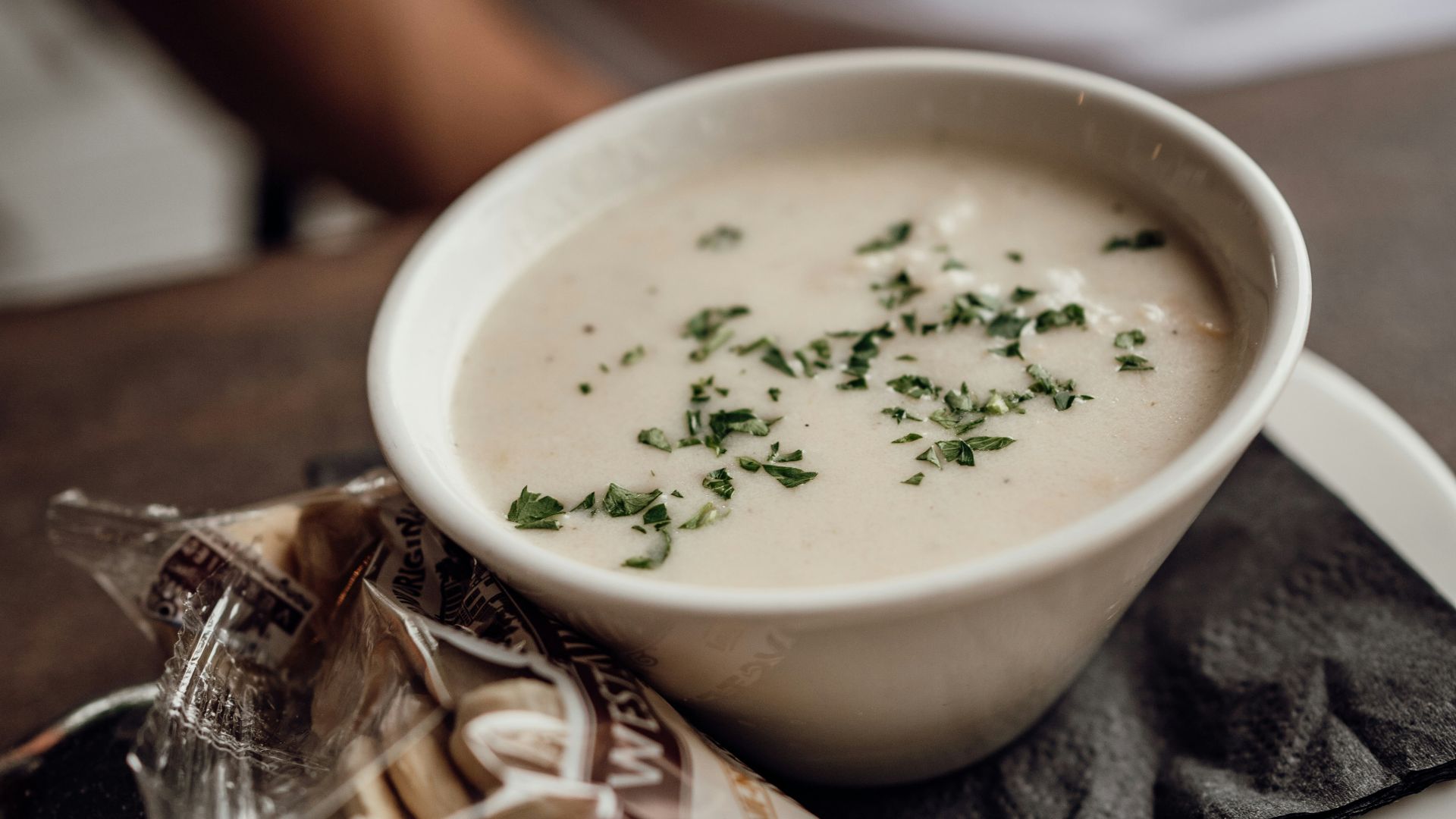 A bowl of soup sitting on top of a white plate