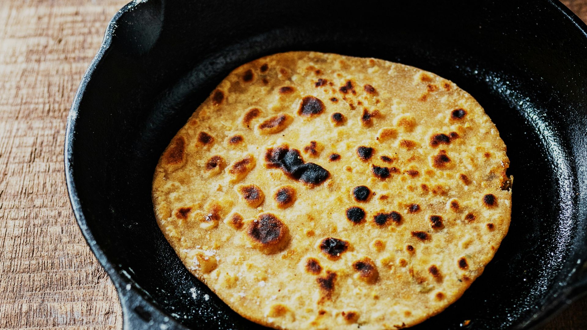 black frying pan on brown wooden table