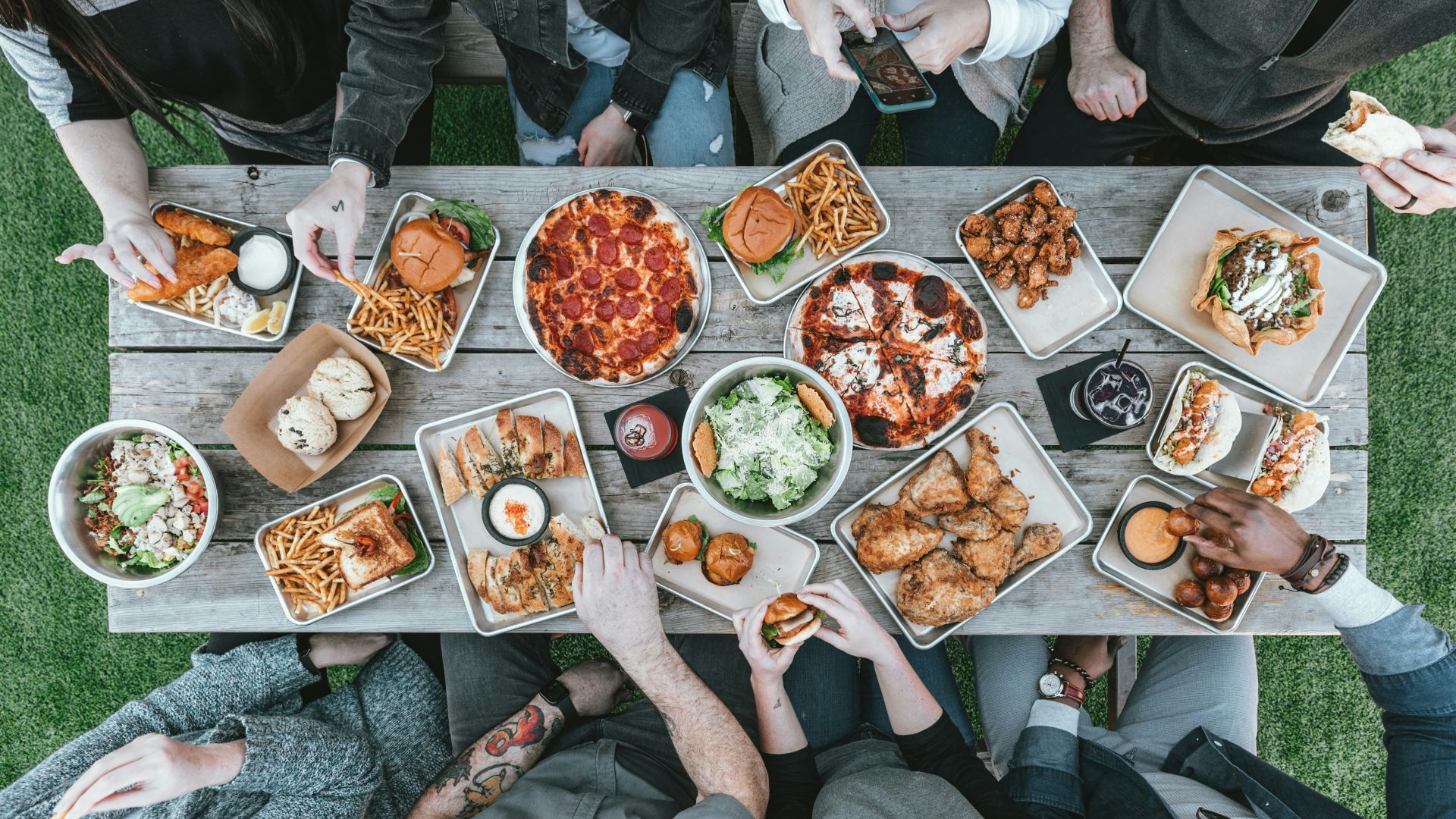a group of people sitting around a table with food