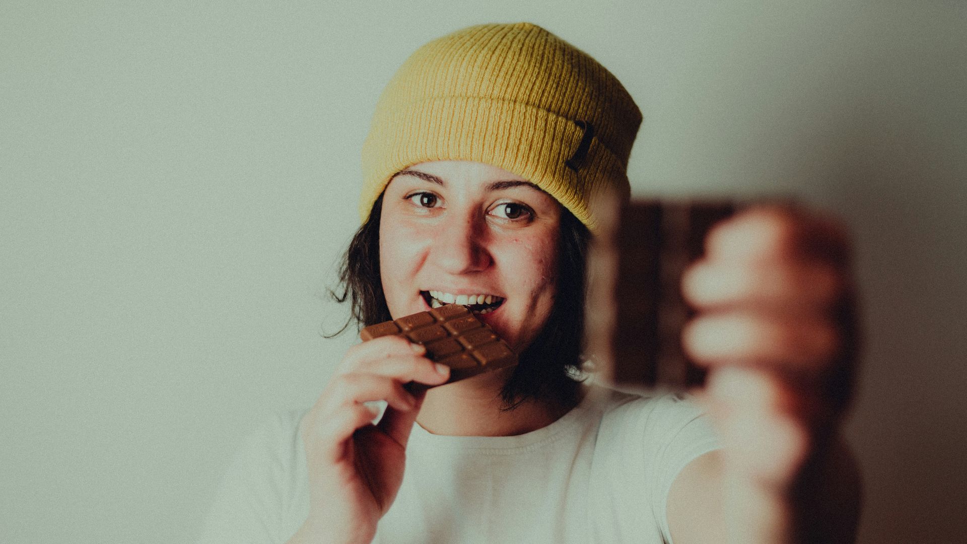 woman in white crew neck t-shirt wearing yellow knit cap