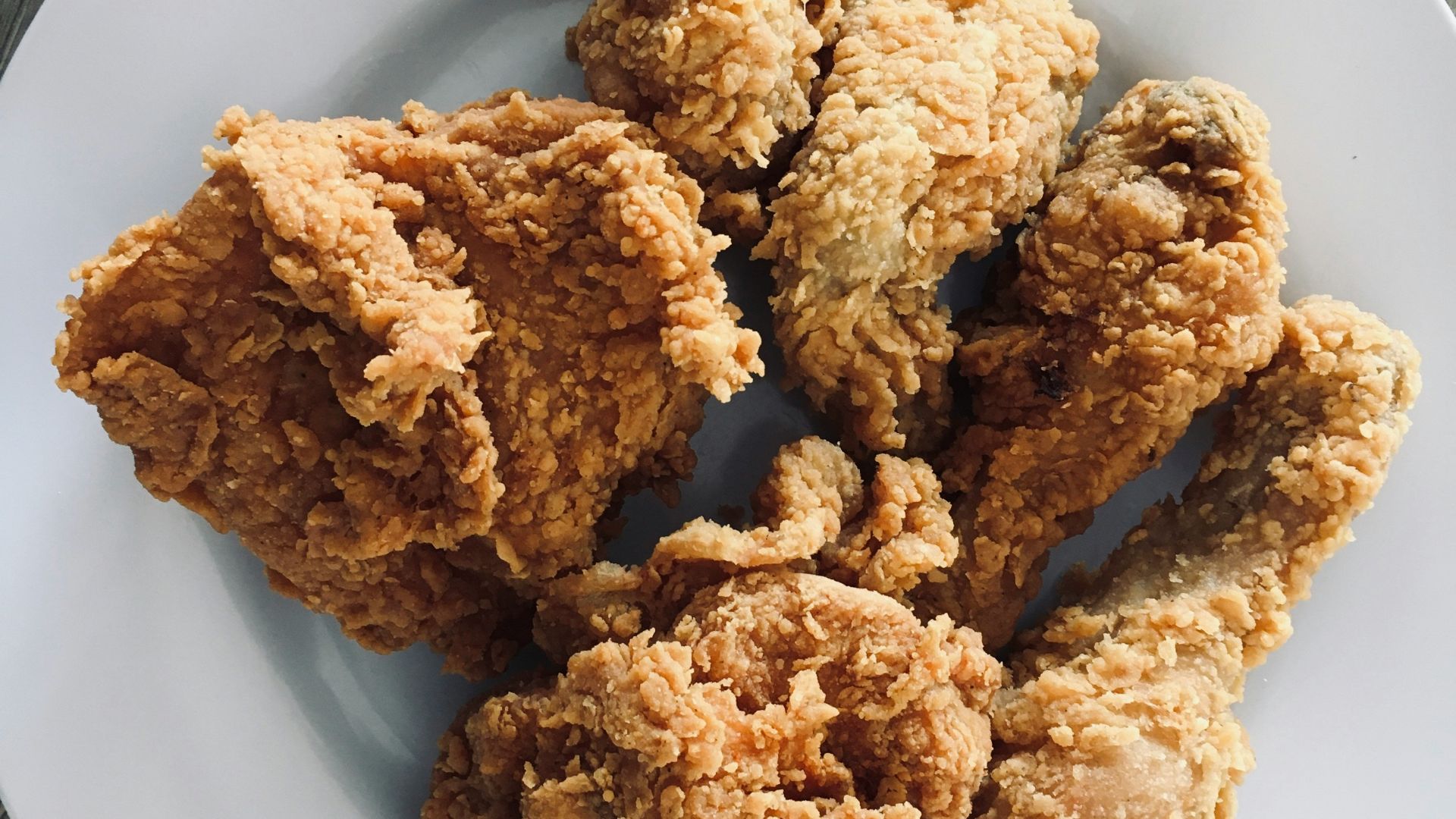 a white plate topped with fried food on top of a wooden table