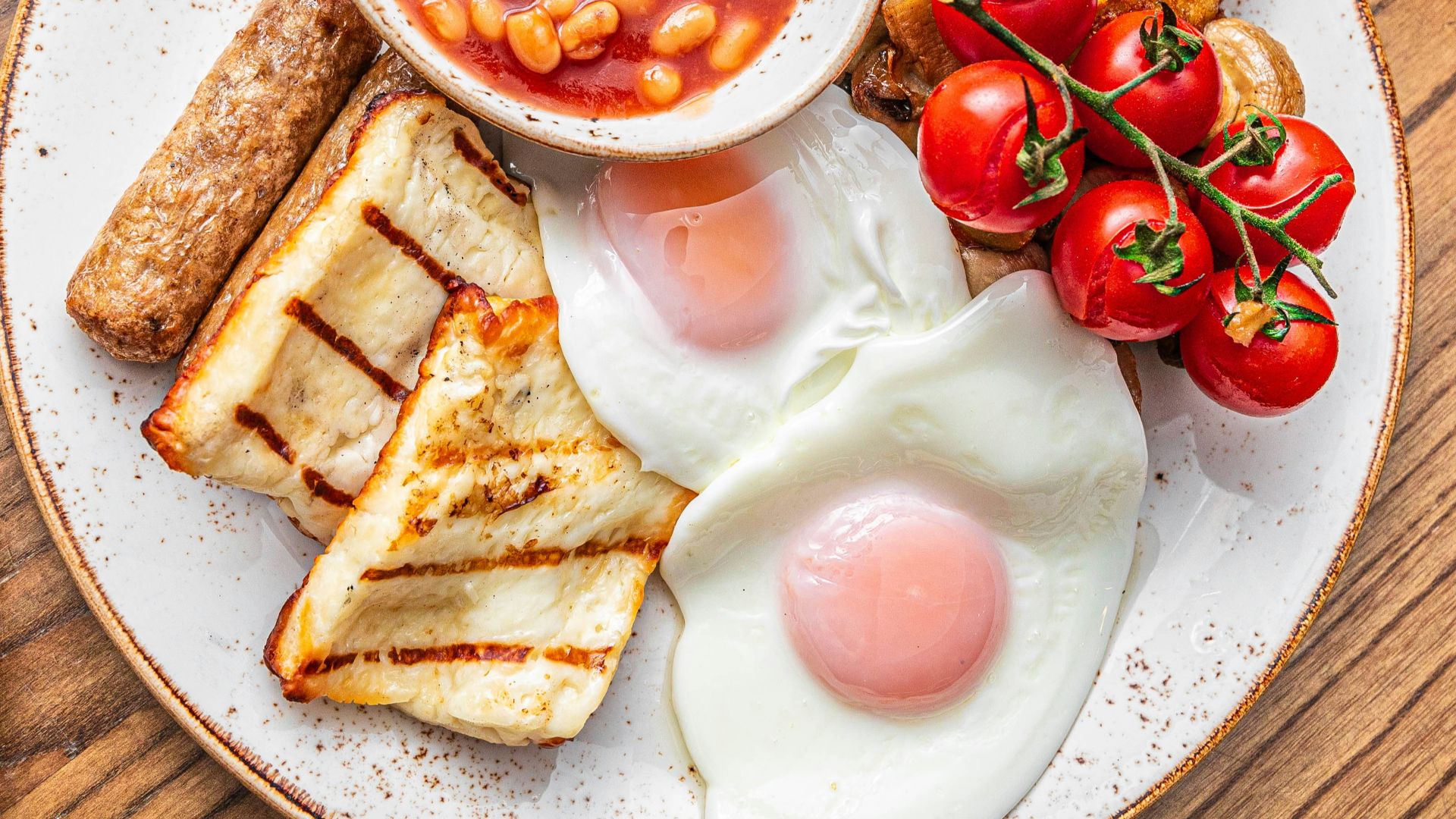 a plate of food with eggs, toast, tomatoes and beans