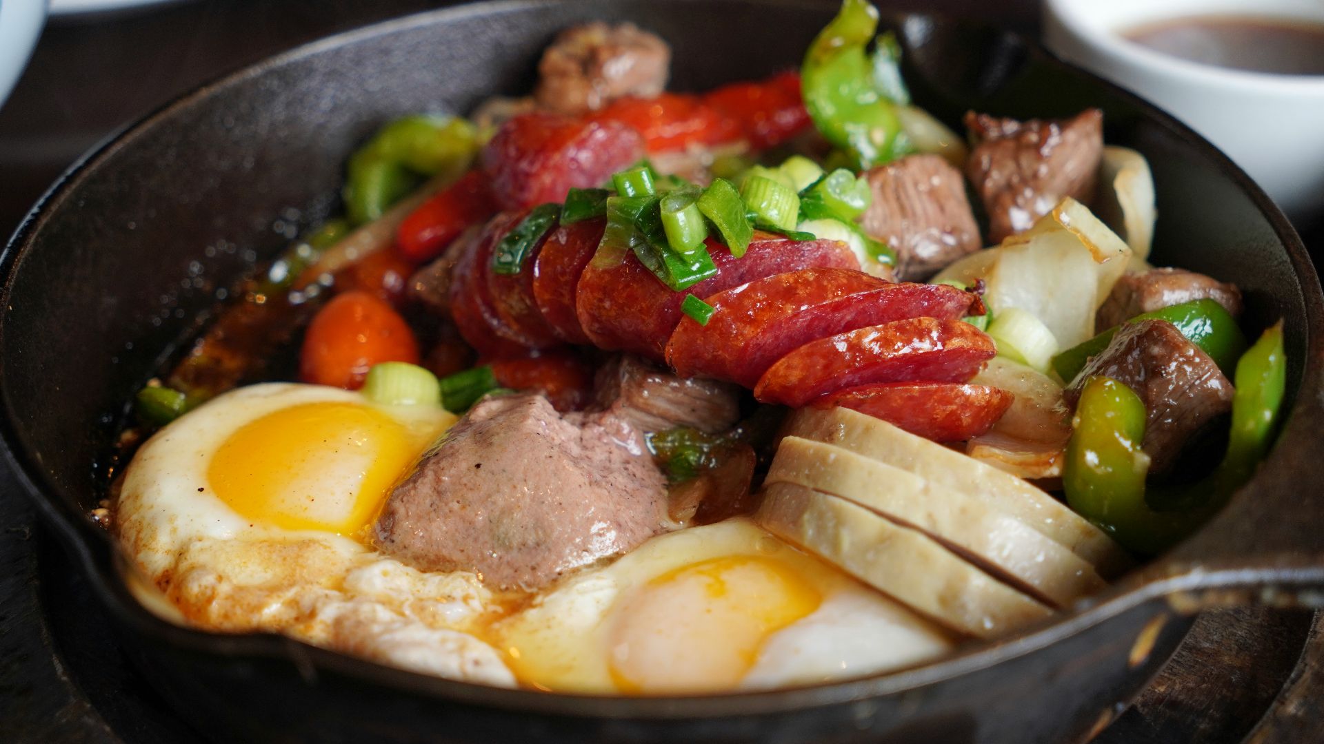 Breakfast skillet with sausage, eggs, and peppers.