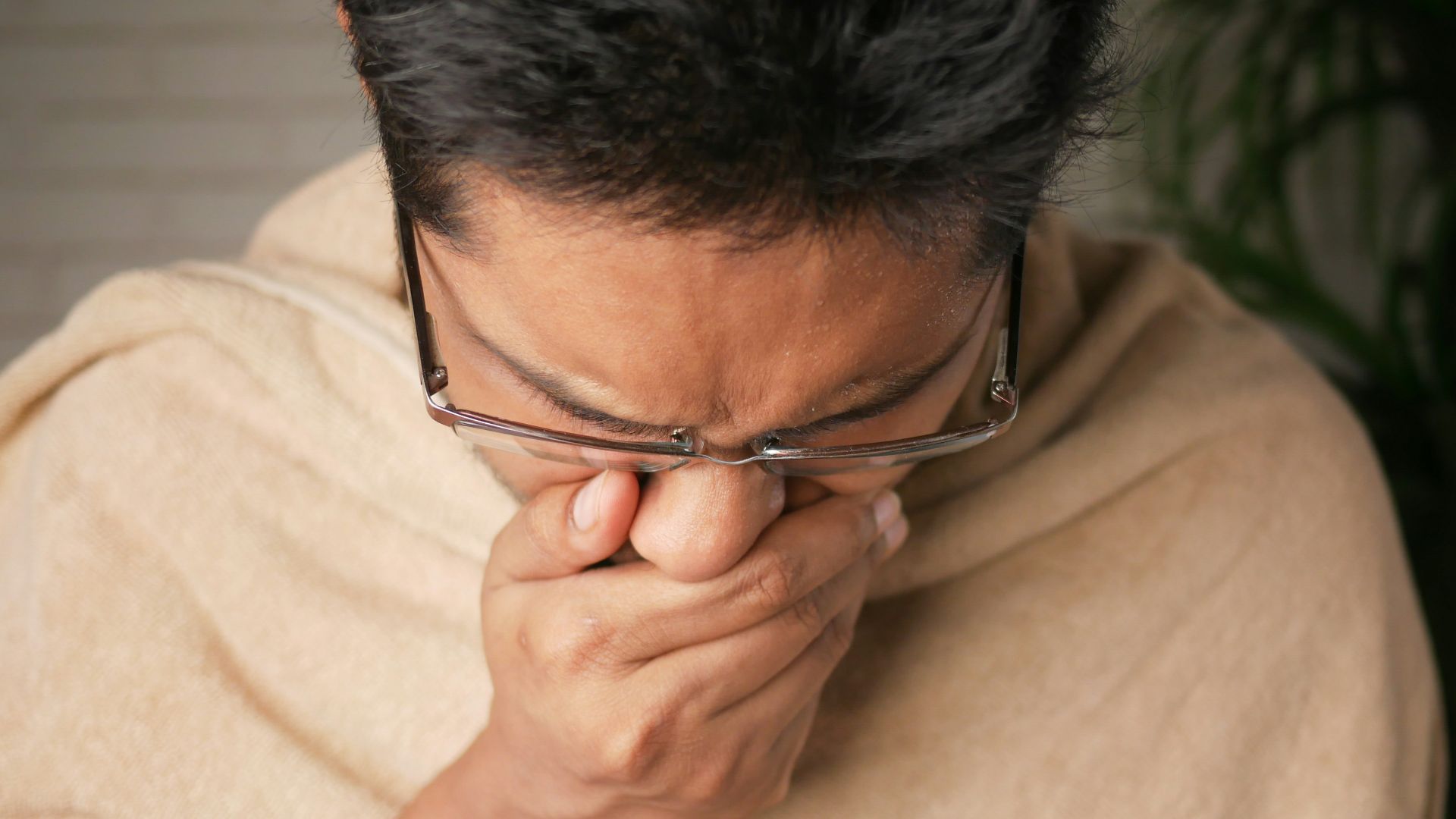 man in brown sweater wearing black framed eyeglasses