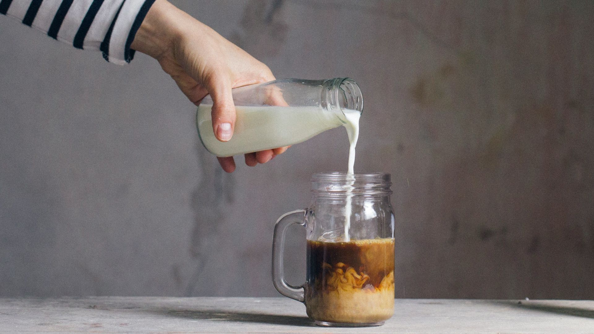 person filling milk on glass