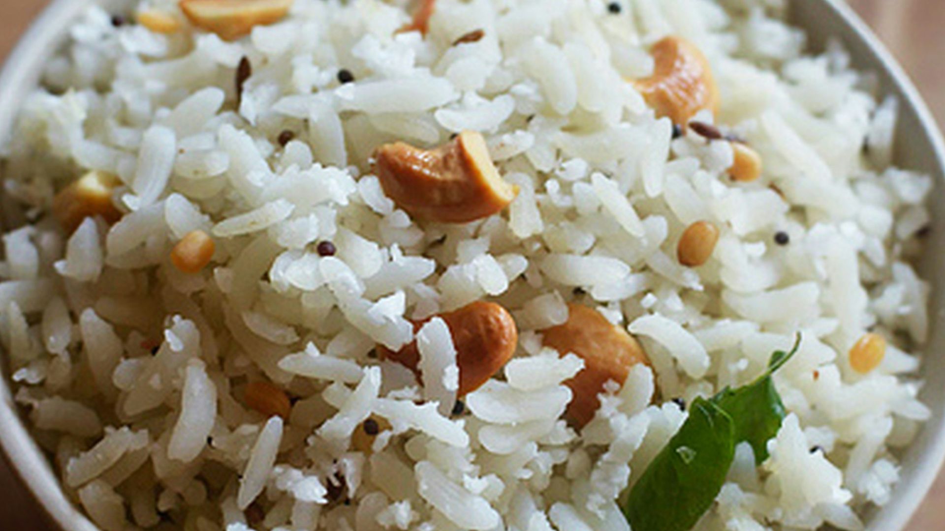 A white bowl filled with rice and nuts