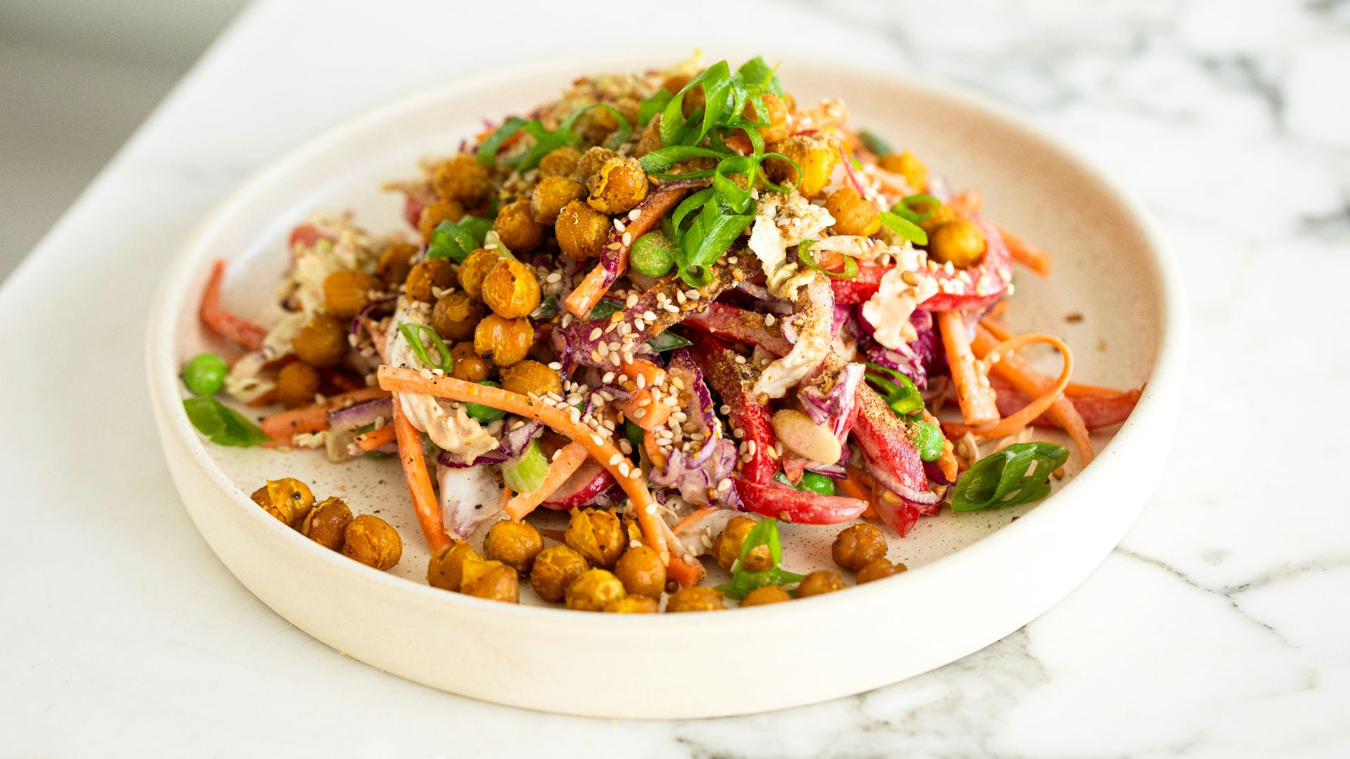 a white bowl filled with a salad on top of a table