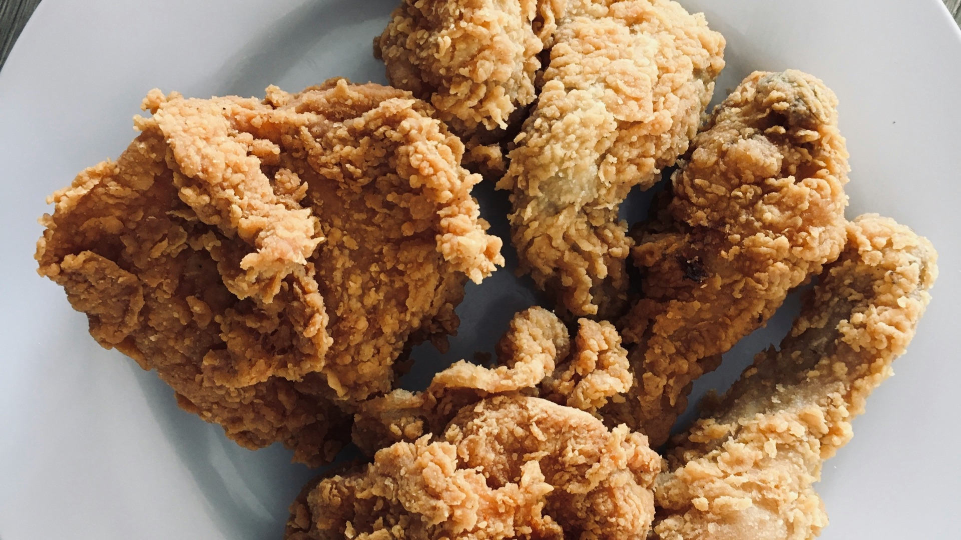 a white plate topped with fried food on top of a wooden table