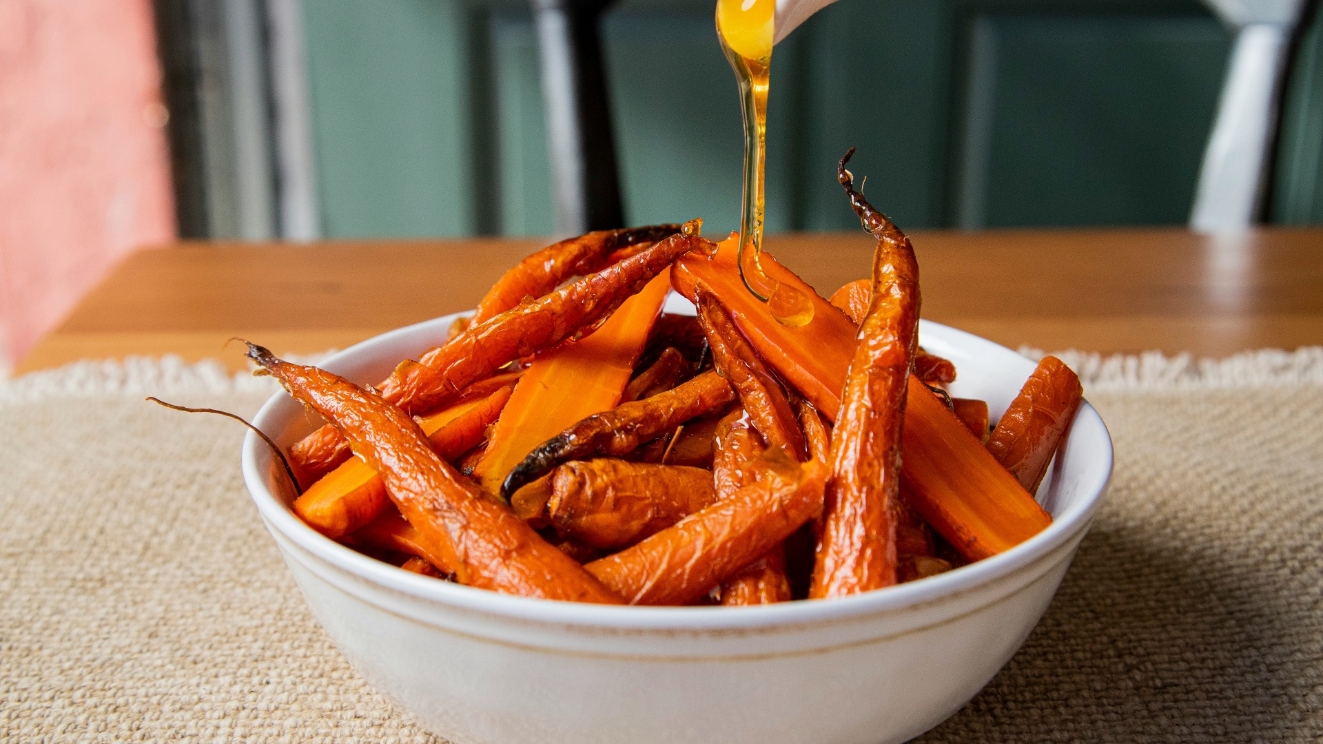 a white bowl filled with carrots sitting on top of a table