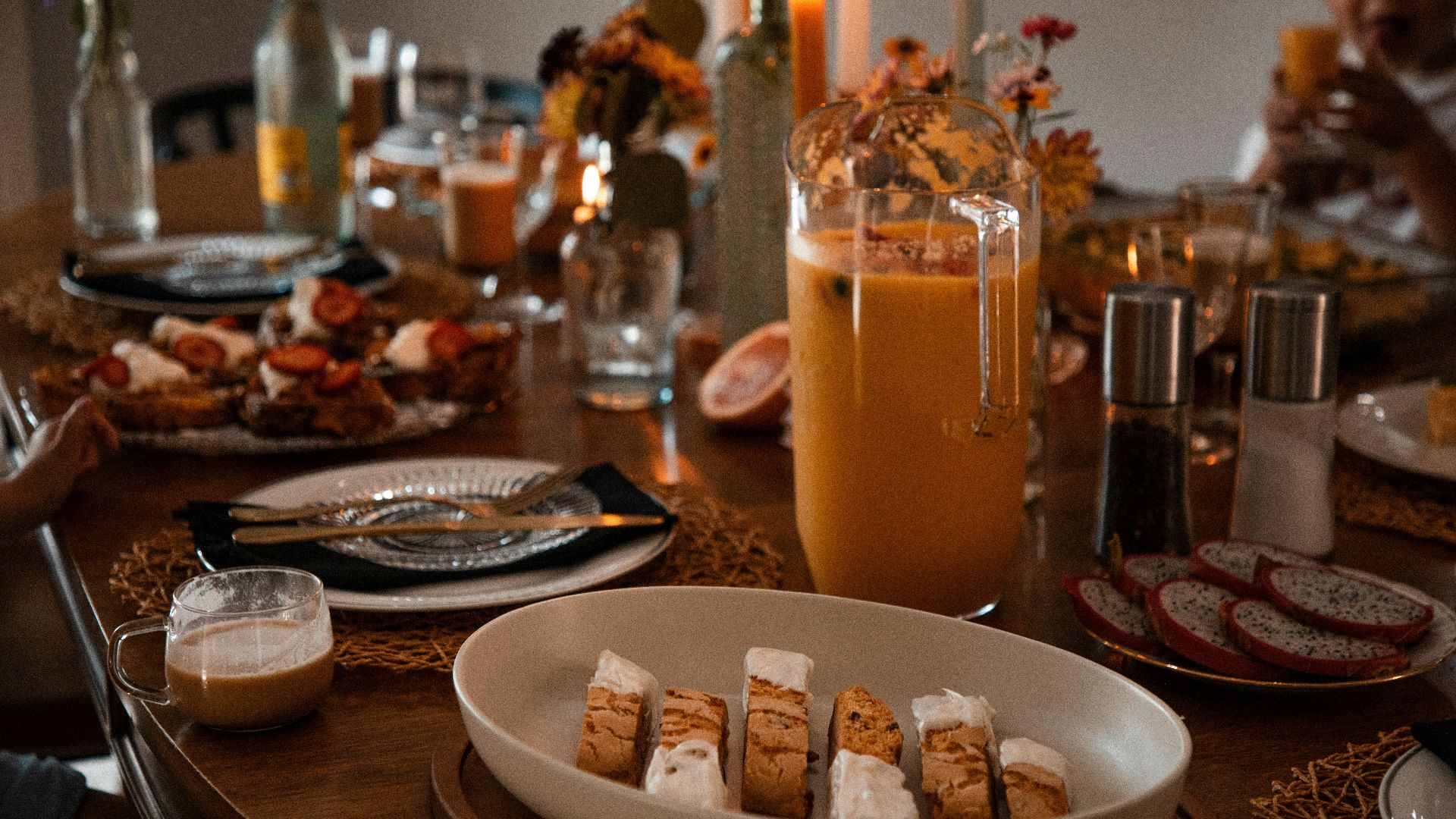 a wooden table topped with plates of food and drinks