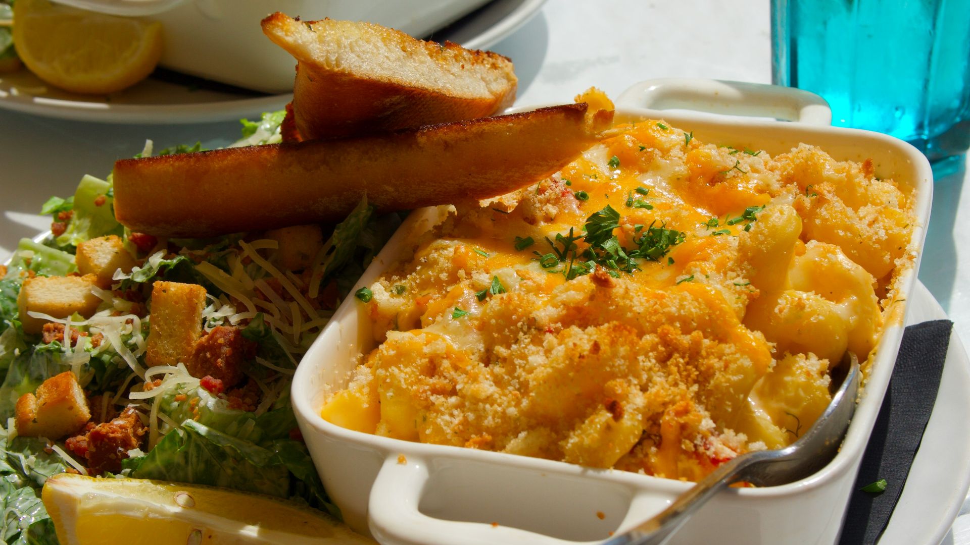 Two servings of macaroni and cheese with salad.