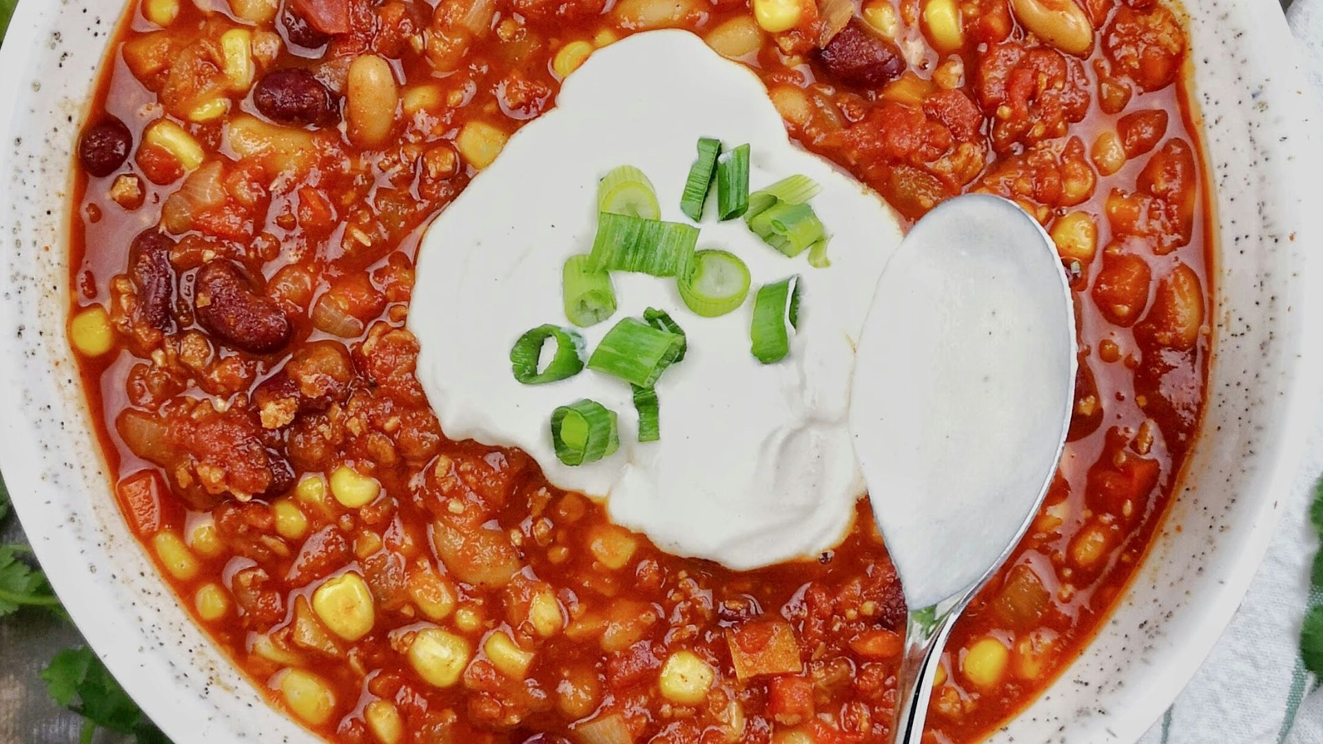 a bowl of chili with sour cream on top