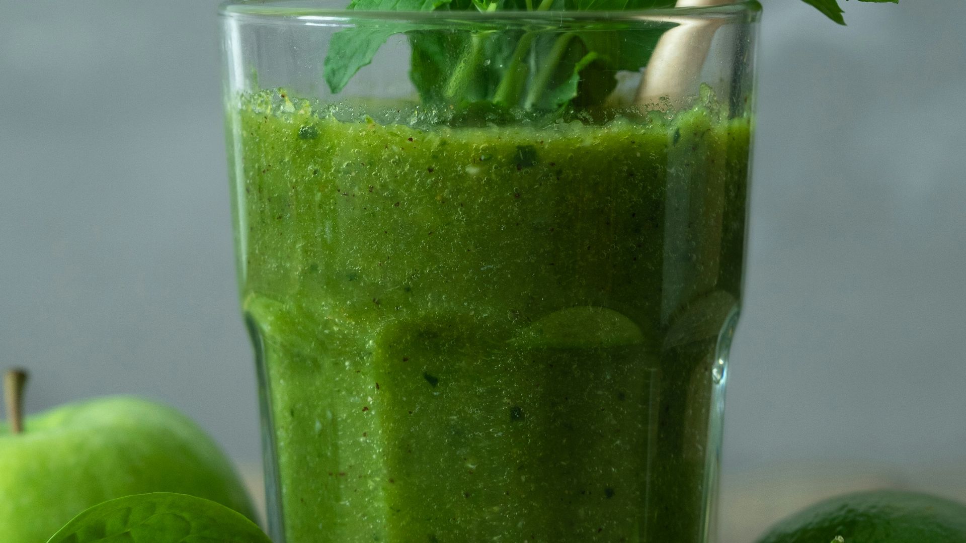 green liquid in clear drinking glass with straw