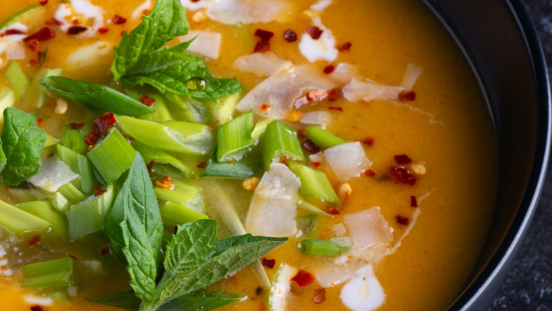soup with green leaf on black ceramic bowl
