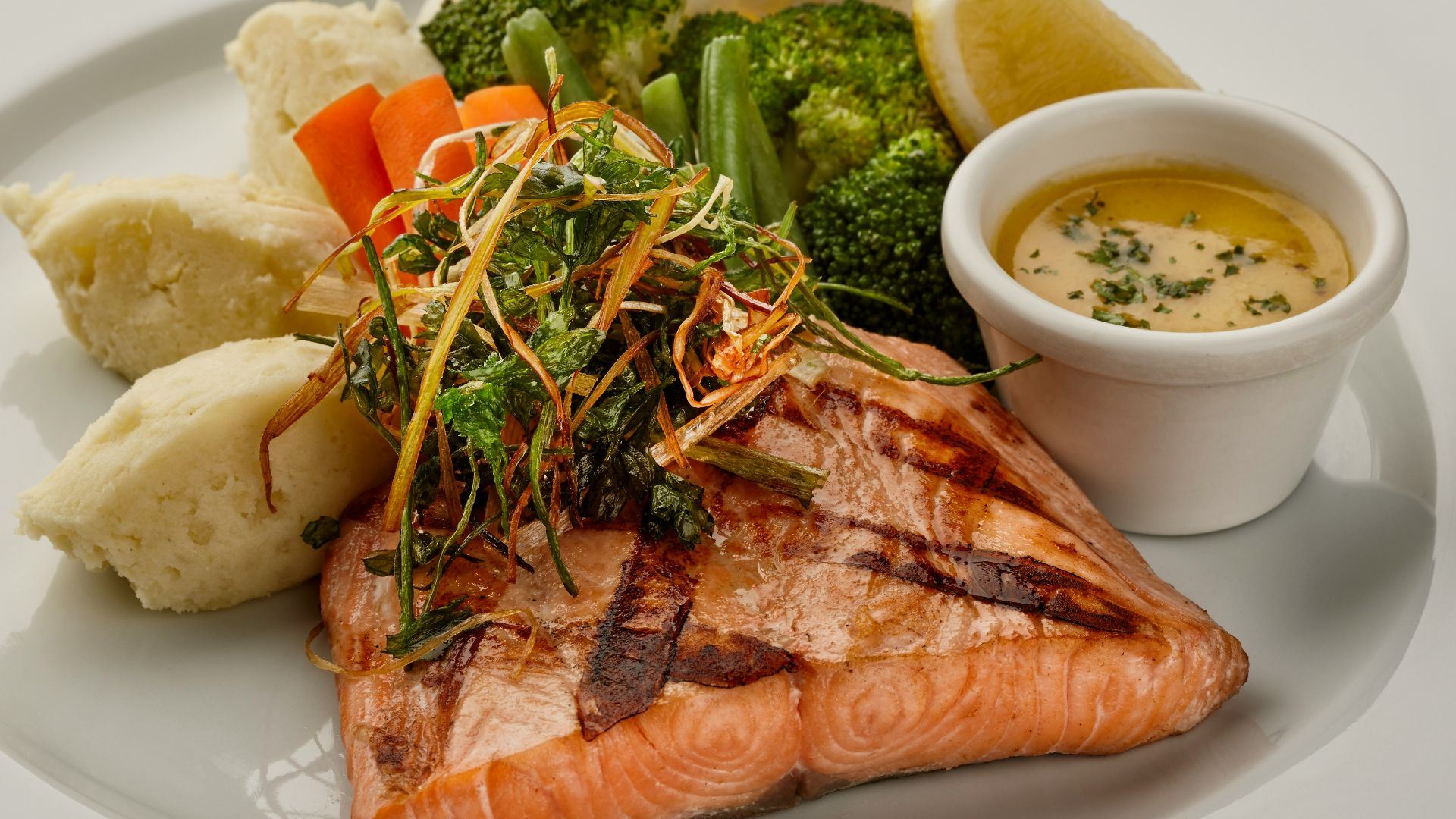 a white plate topped with fish and vegetables