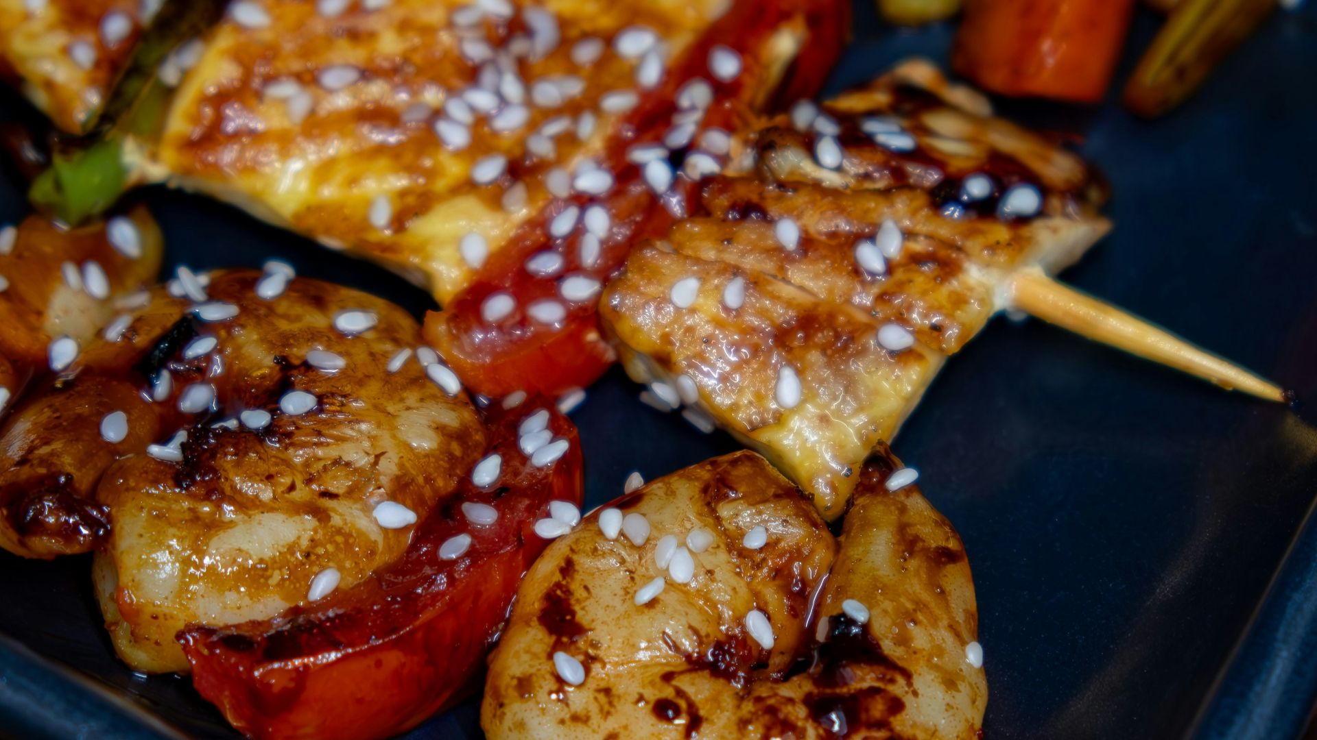 A black plate topped with meat and veggies