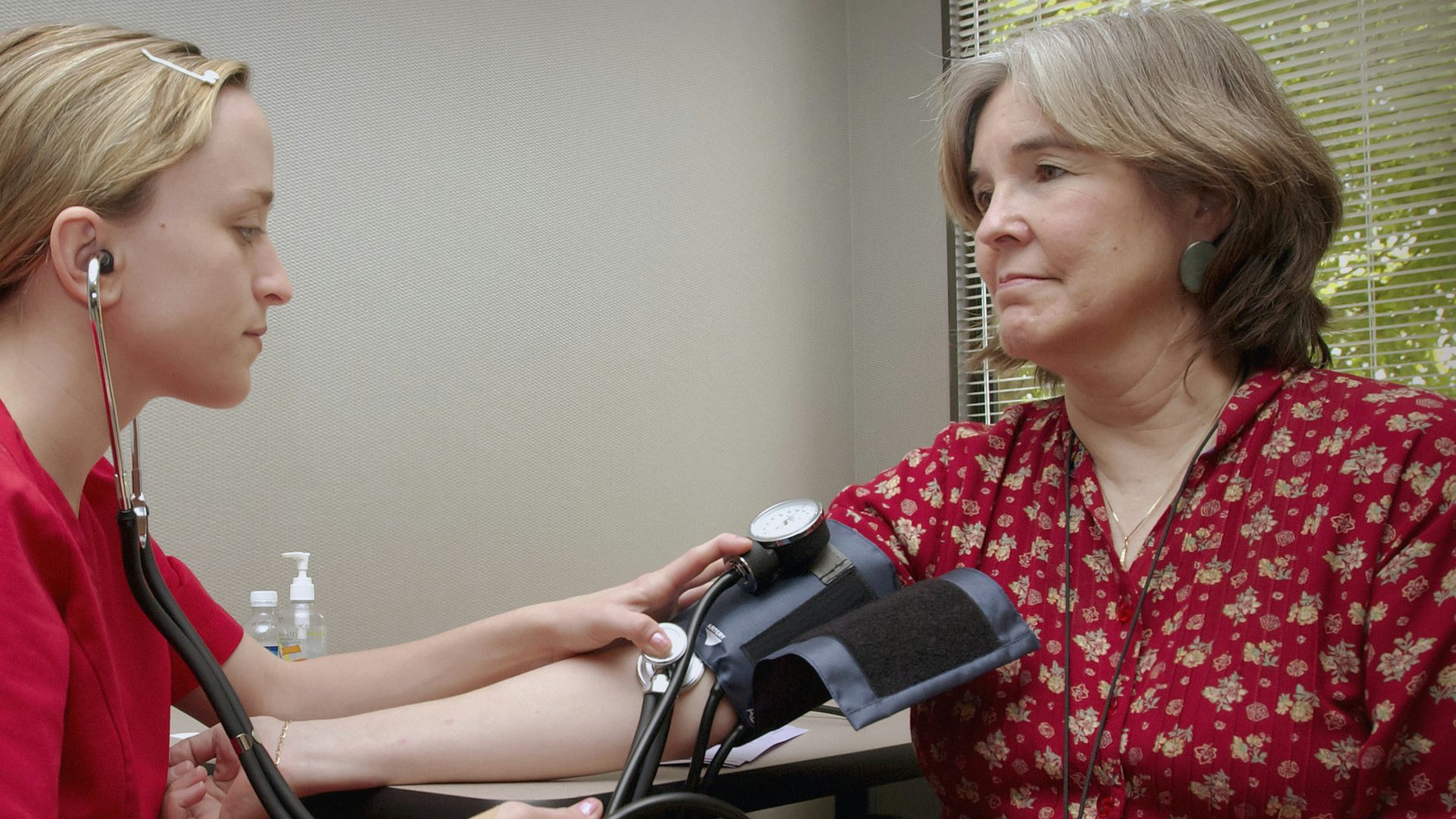 a woman with a stethoscope listening to a patient