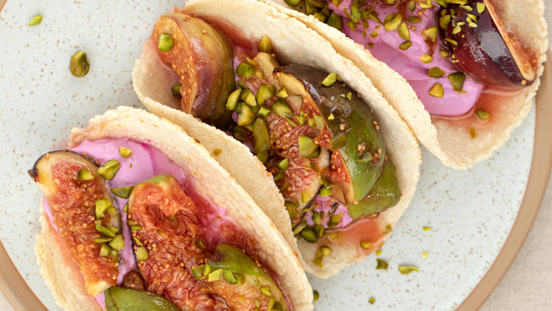 three tacos on a plate on a table