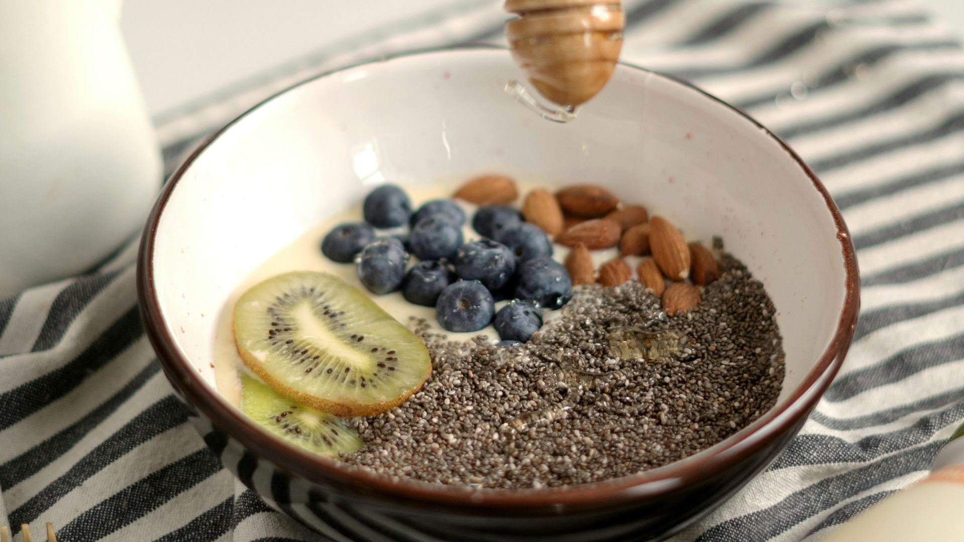 a bowl of oatmeal with blueberries, bananas, and a honey